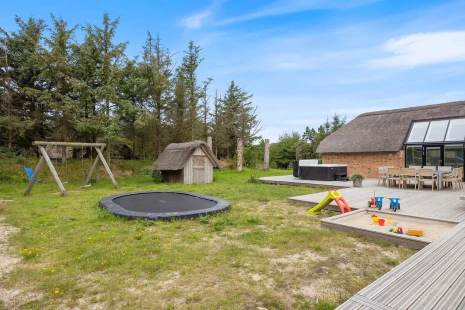 Una zona de juegos al aire libre con un columpio y una pequeña casita de madera.