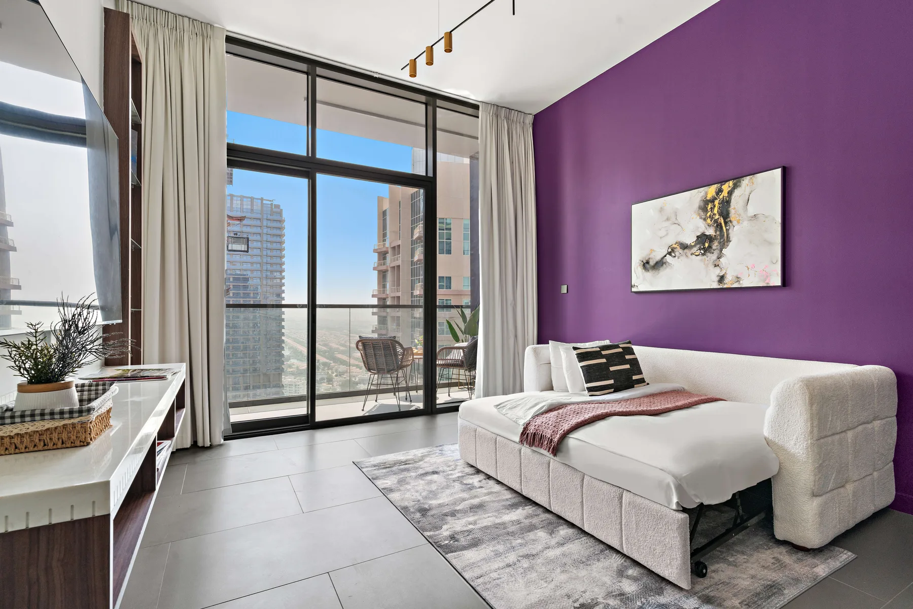 Un dormitorio moderno con una cama junto a una puerta de vidrio y una pared morada.