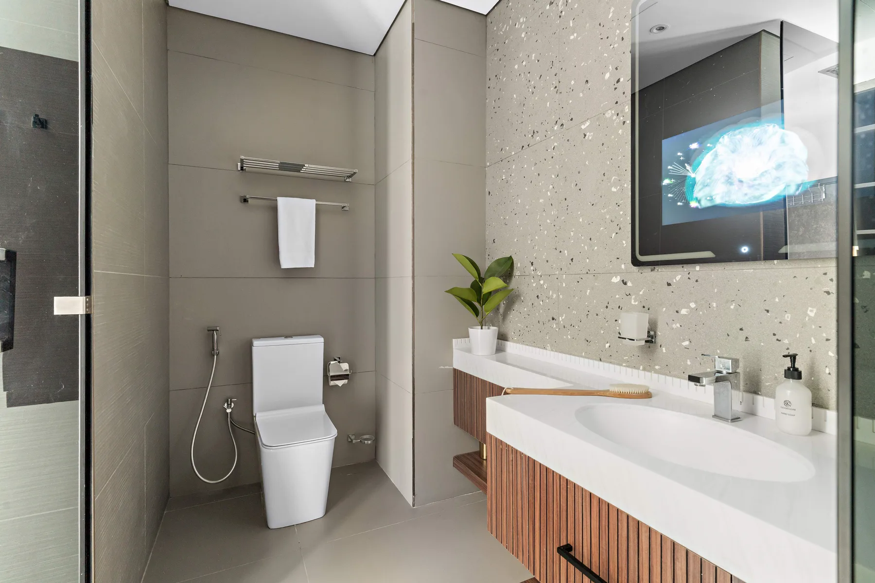Un baño moderno con inodoro, toallero de pared y lavabo.