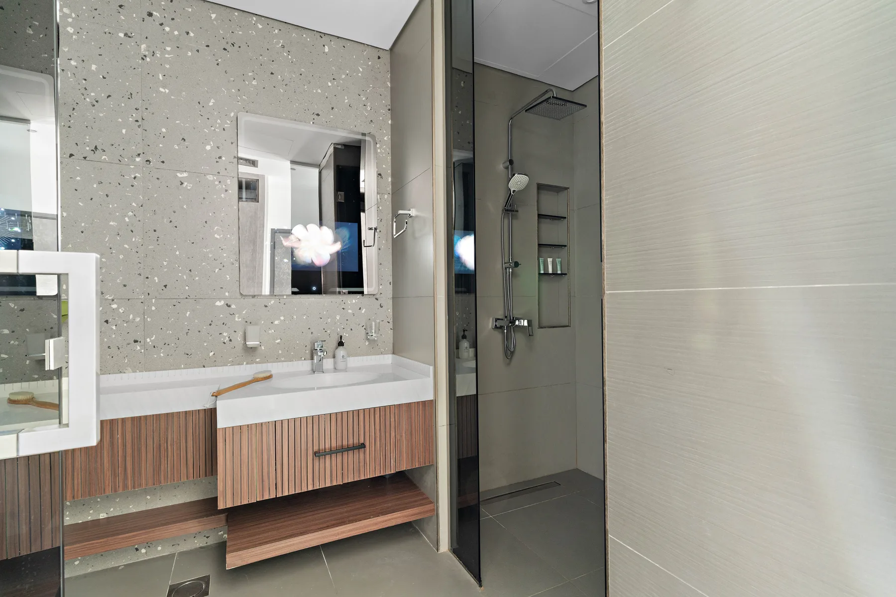 Un baño moderno con lavabo y una ducha con mampara de vidrio.