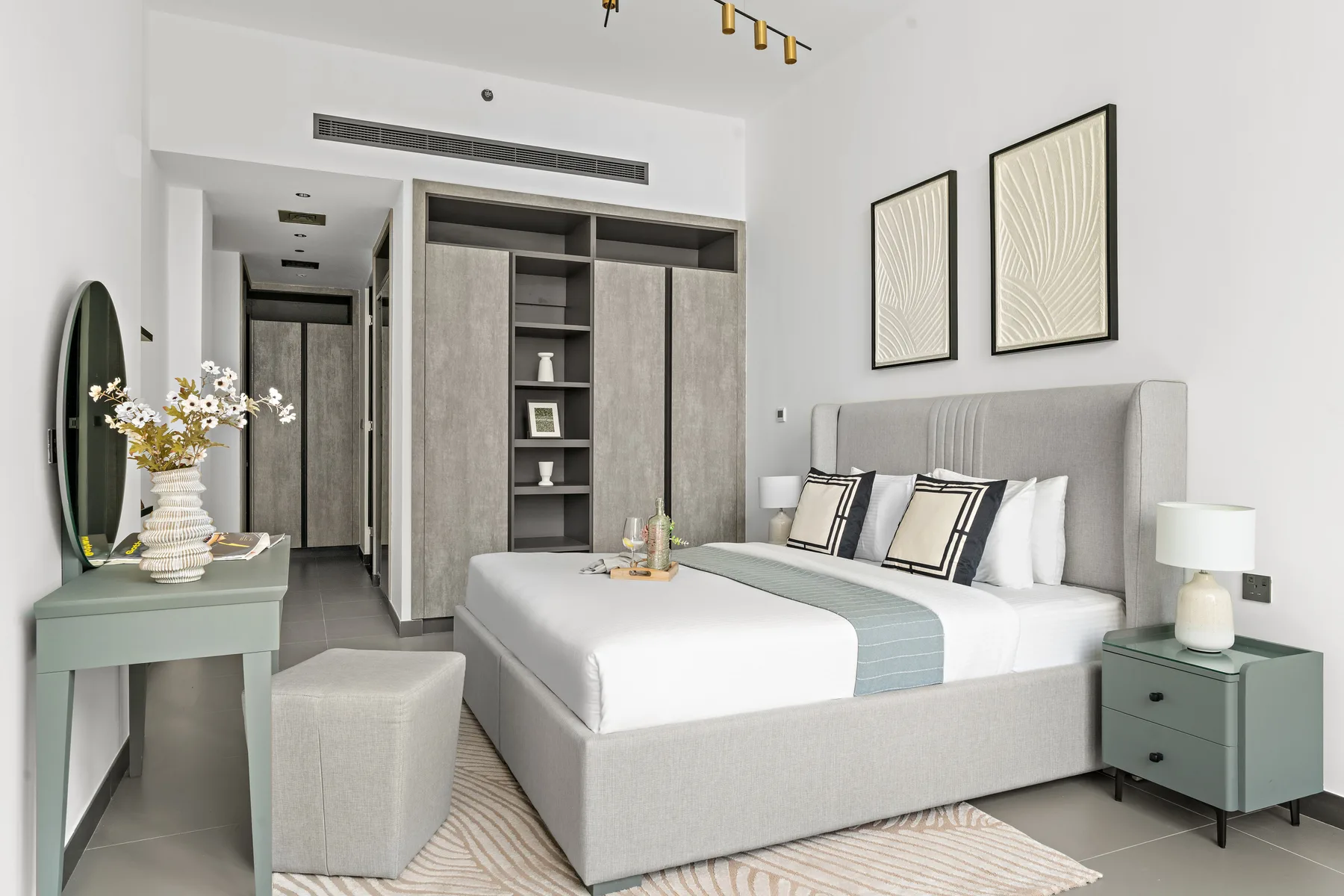 Un dormitorio moderno con una cama tendida y estanterías empotradas.