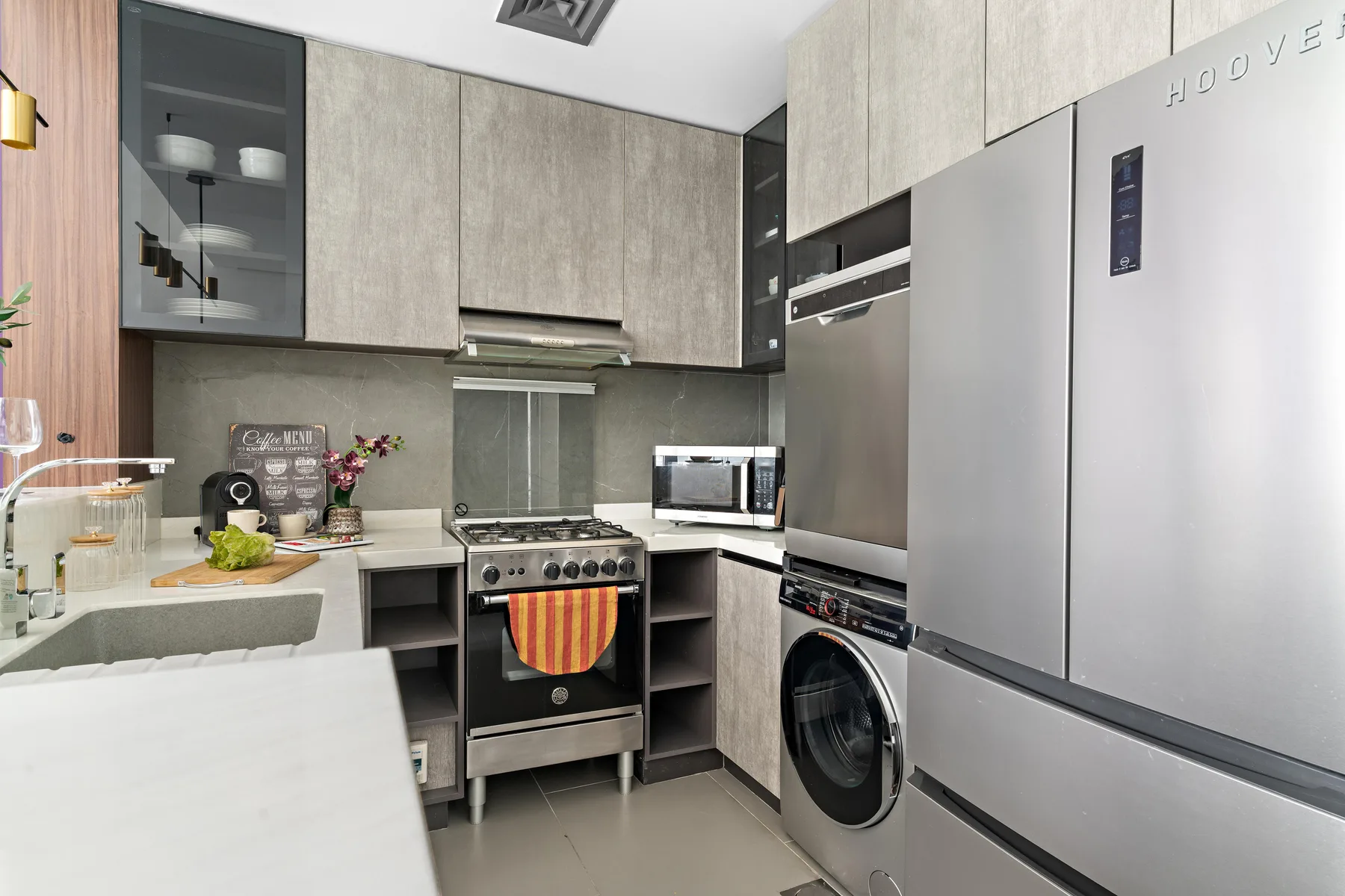 Una cocina moderna con estufa, encimera y electrodomésticos de acero inoxidable.