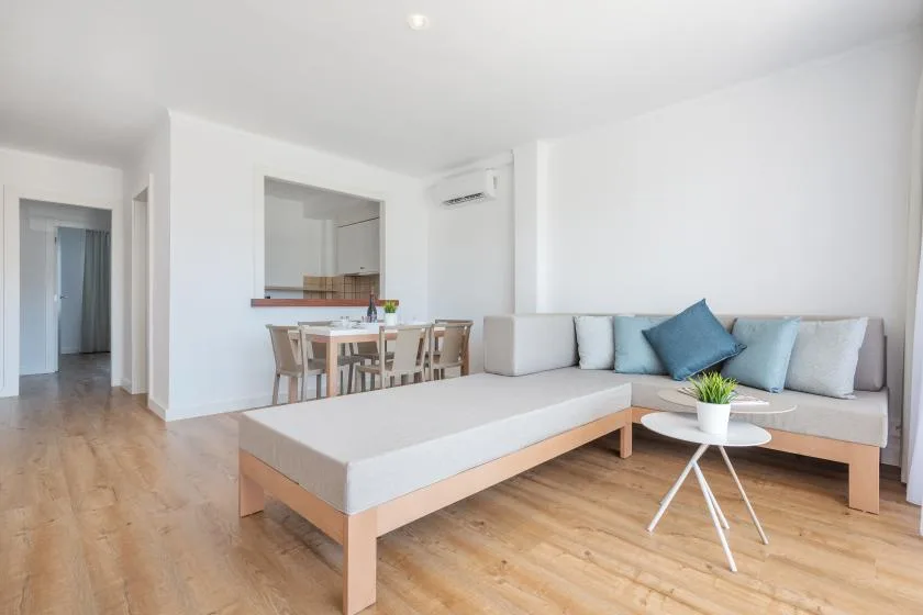 Bright living room with light seating and a dining area.