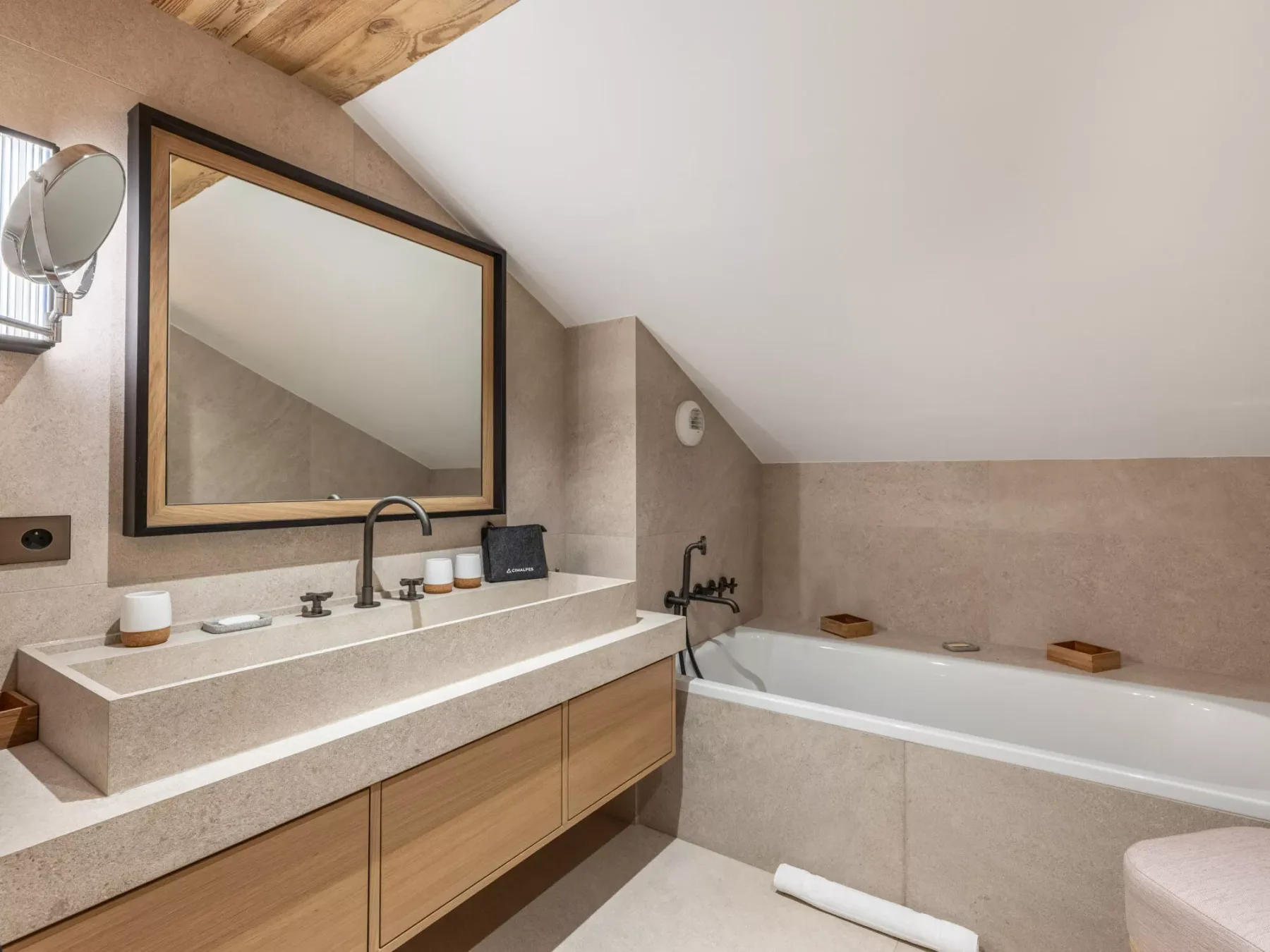 A bathroom with a wide vanity, large mirror, and bathtub.