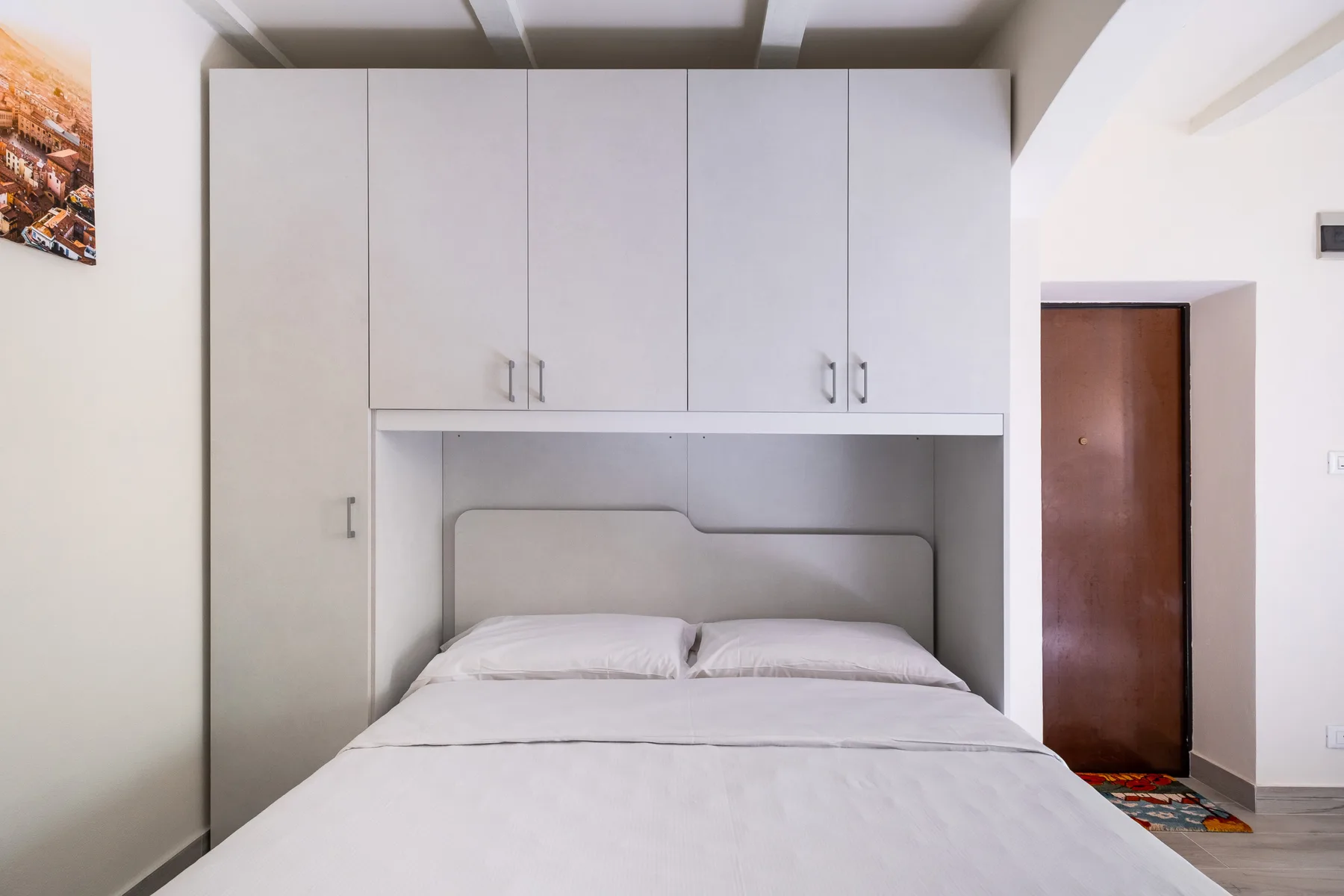 Un dormitorio con una cama debajo de armarios empotrados.
