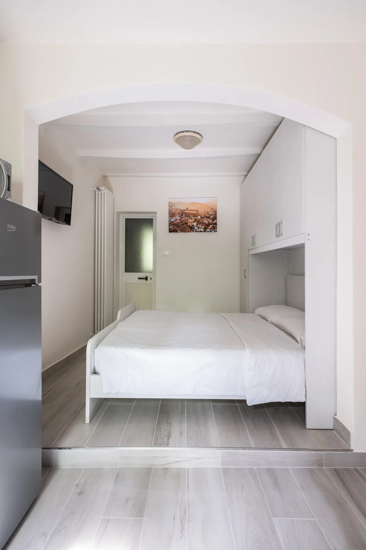 Un dormitorio con una cama bien arreglada y armarios empotrados.