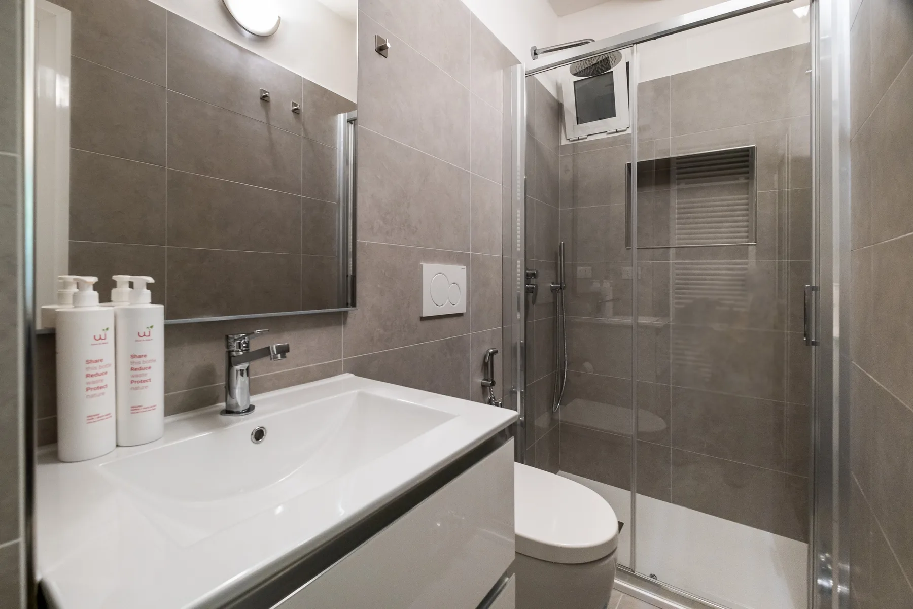 A bathroom with a white sink and a glass shower.