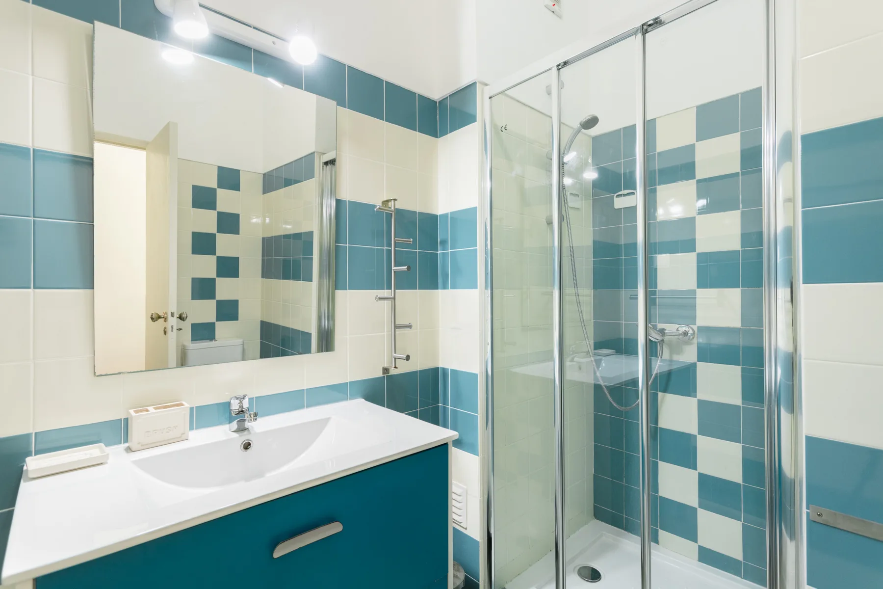 A tiled bathroom with a sink and glass shower.