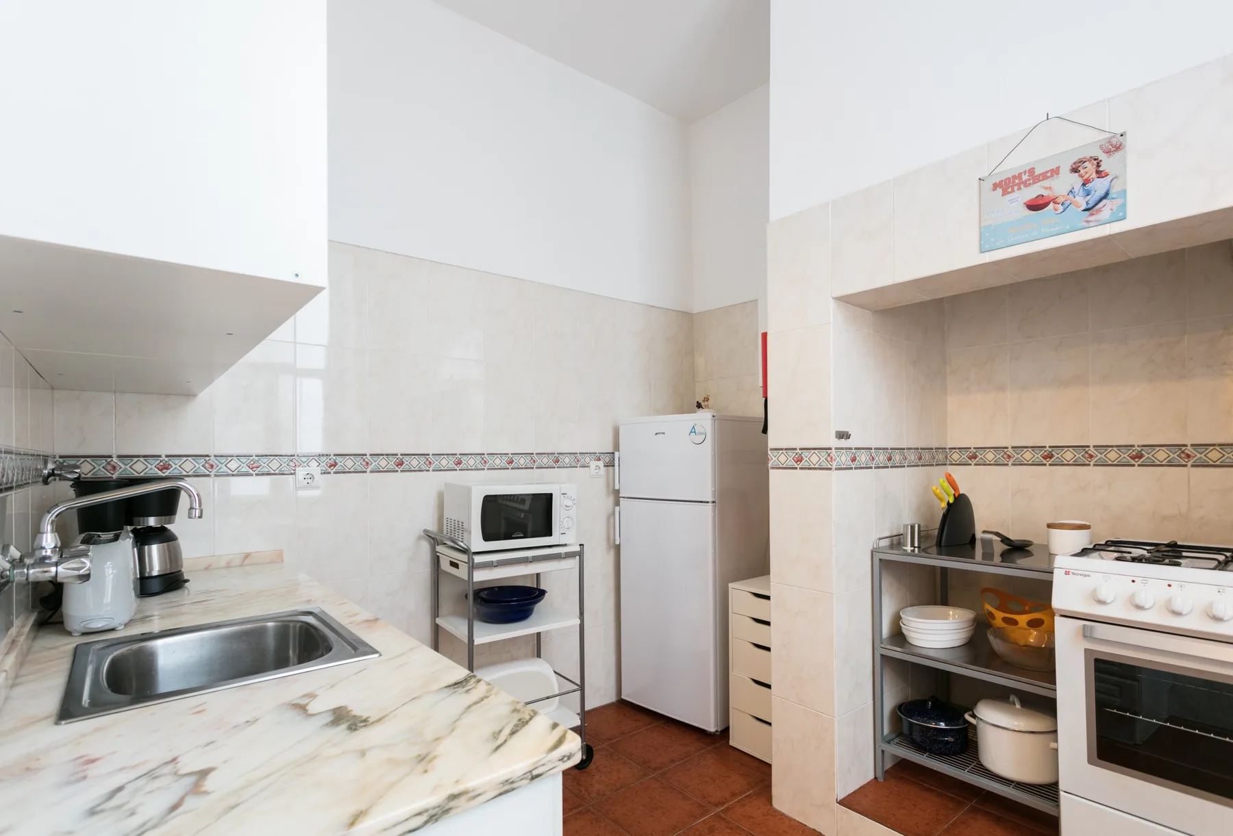 A compact kitchen with a sink, refrigerator, and cooking area.