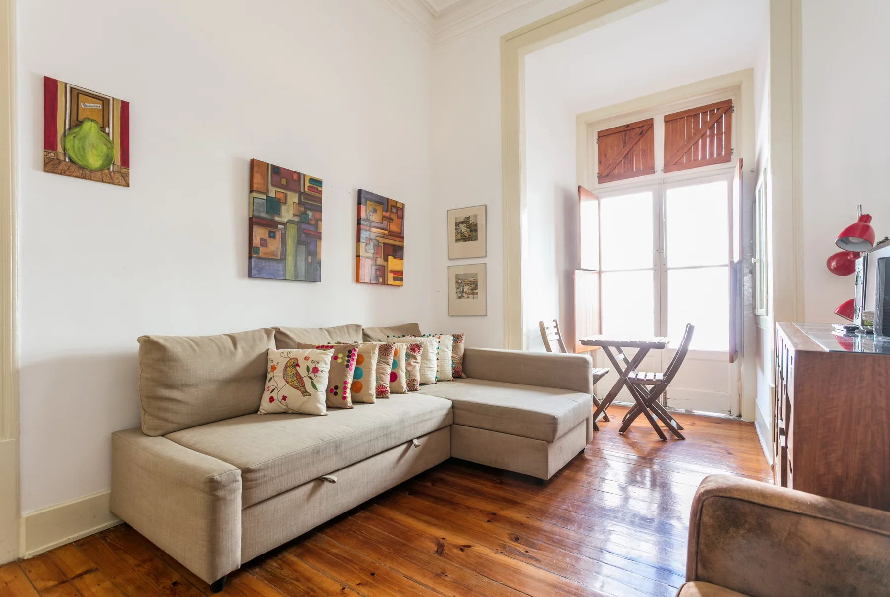 A bright living room with a sectional sofa and tall windows.