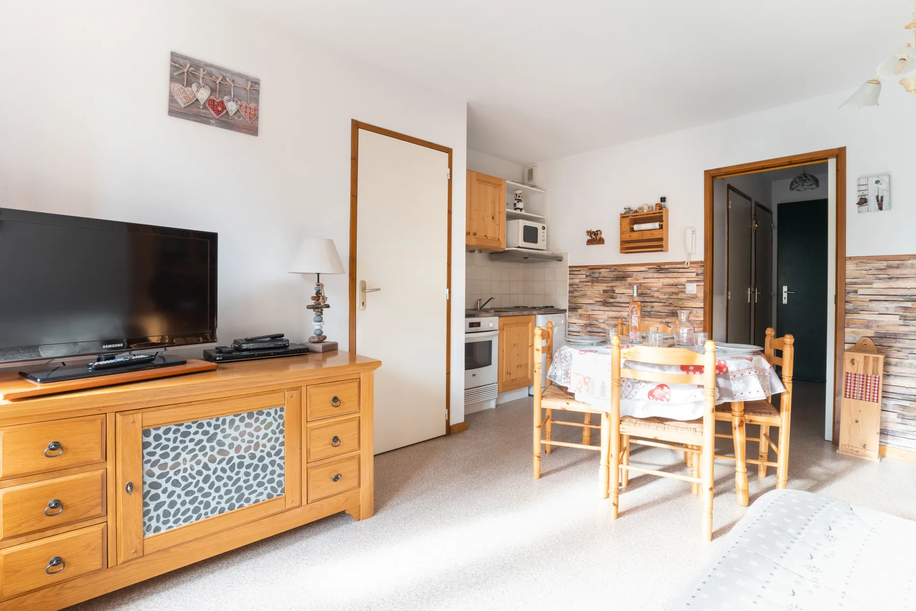 A dining area with a table and chairs beside a compact kitchen.