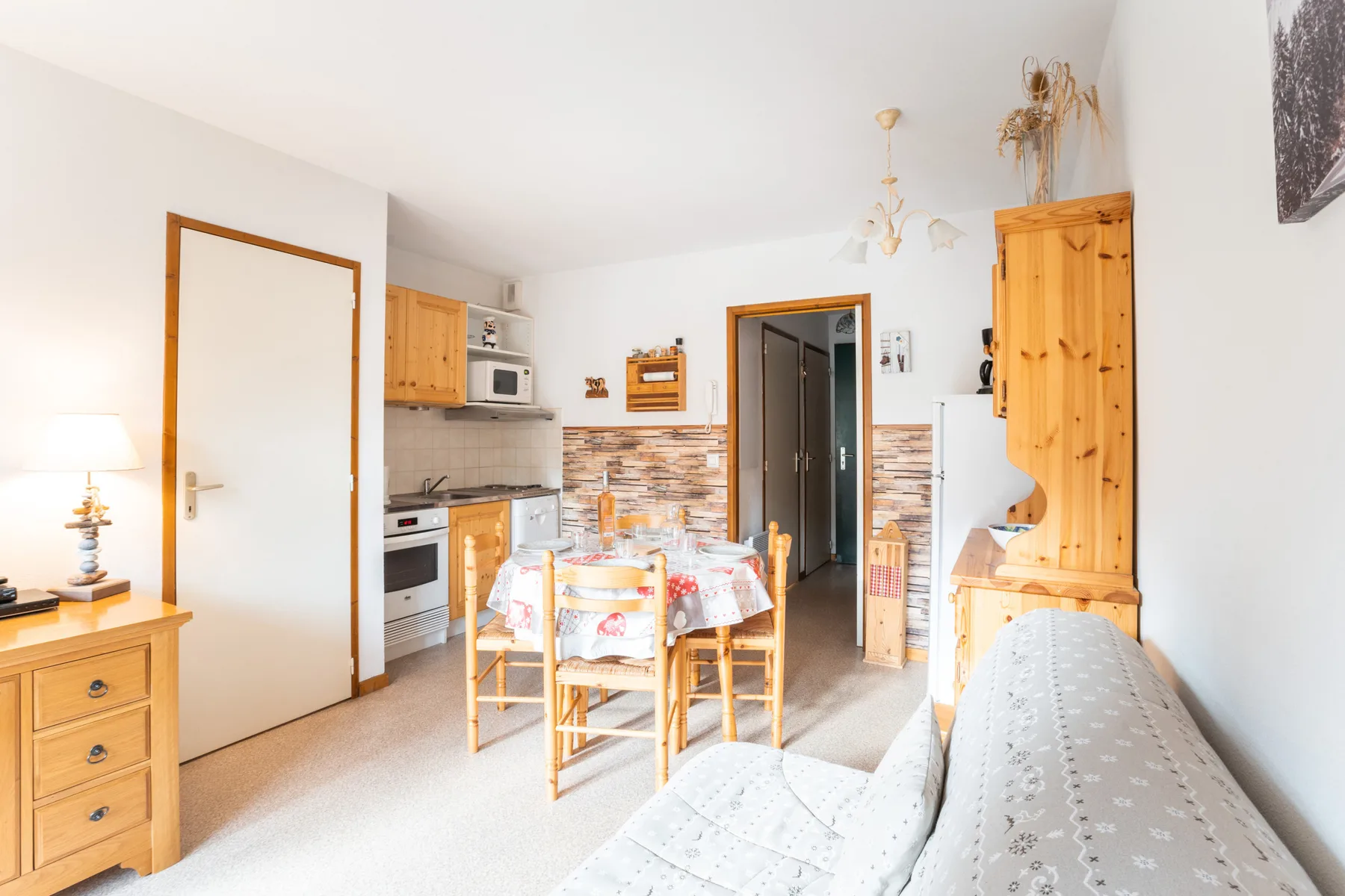 A bright apartment kitchen and dining area with a table beside the cooking space.