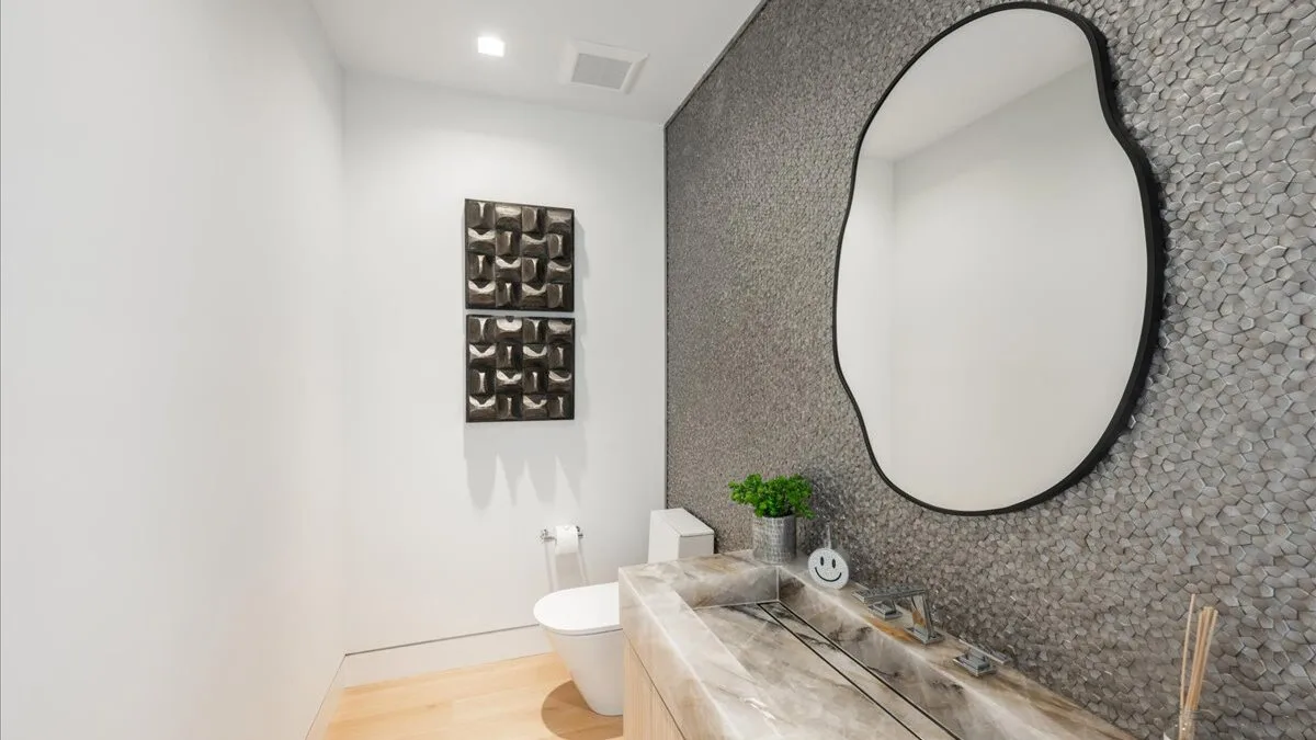 Un baño moderno con una pared estampada y un espejo grande sobre el lavabo.