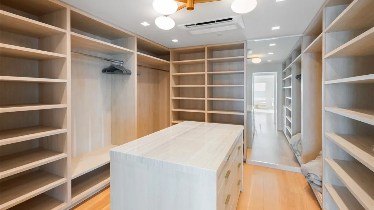 Un vestidor con estanterías abiertas y una isla central.