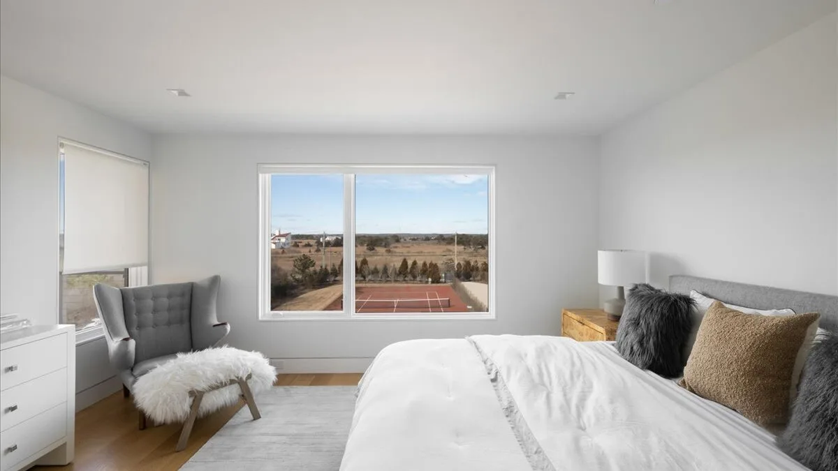 Un dormitorio luminoso con una ventana grande que da a un paisaje.