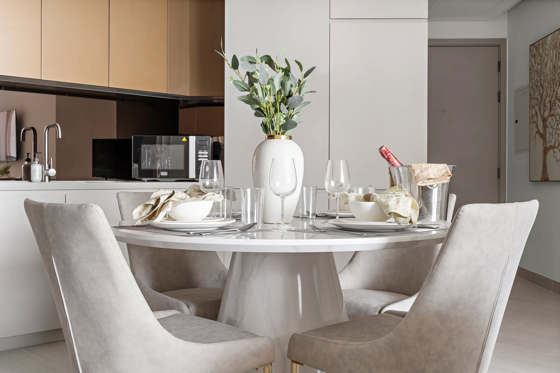 A dining area with a set table and flowers in a vase.