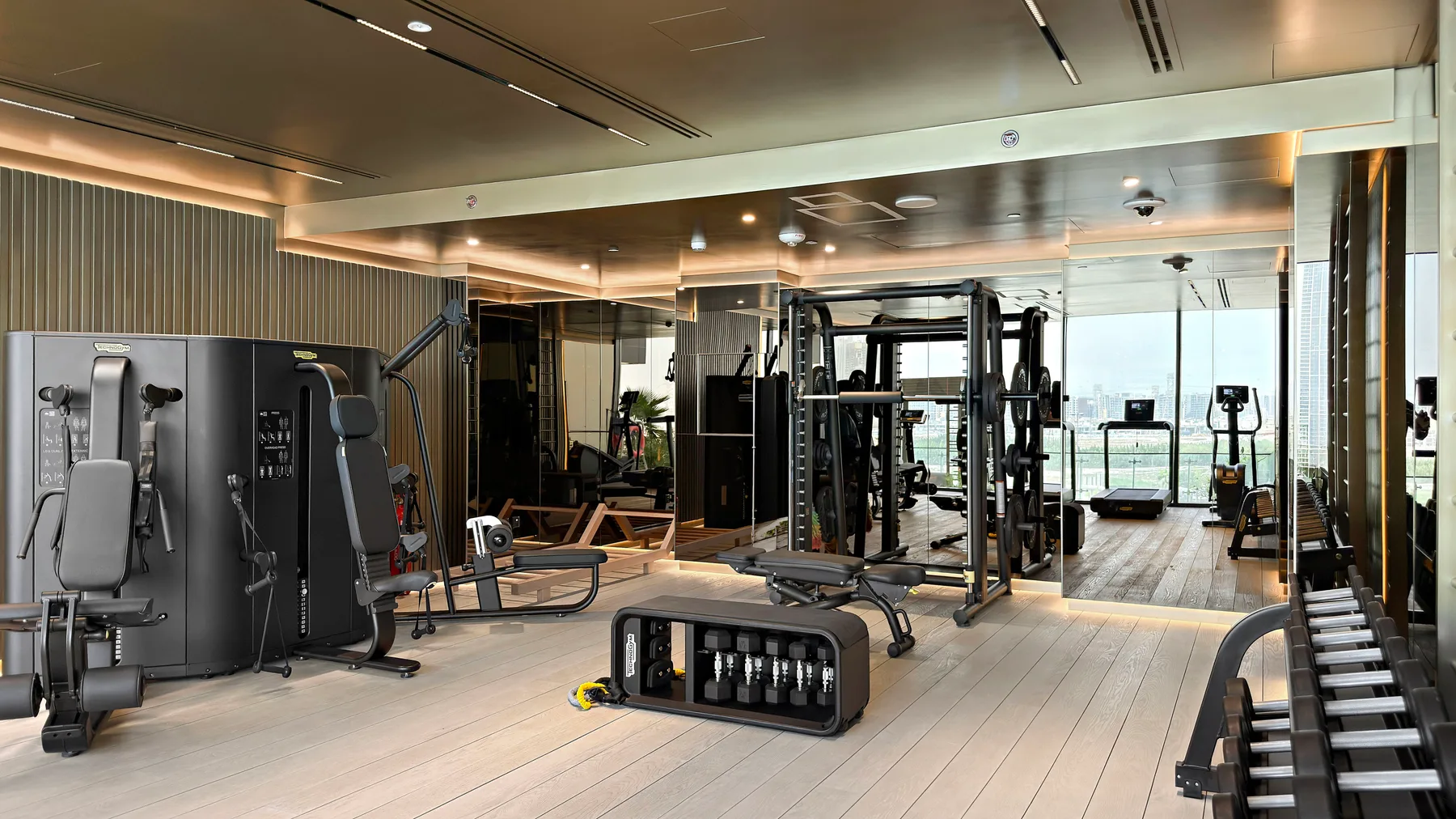A spacious gym with strength-training equipment and treadmills.