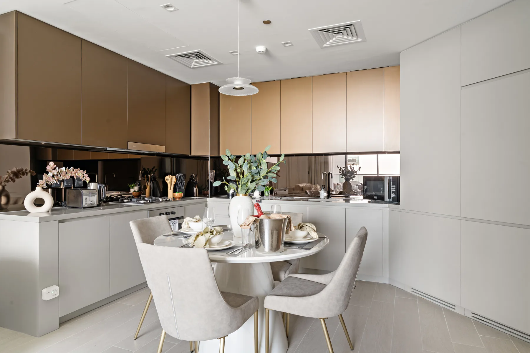 A bright modern kitchen with a round dining table and upholstered seating.