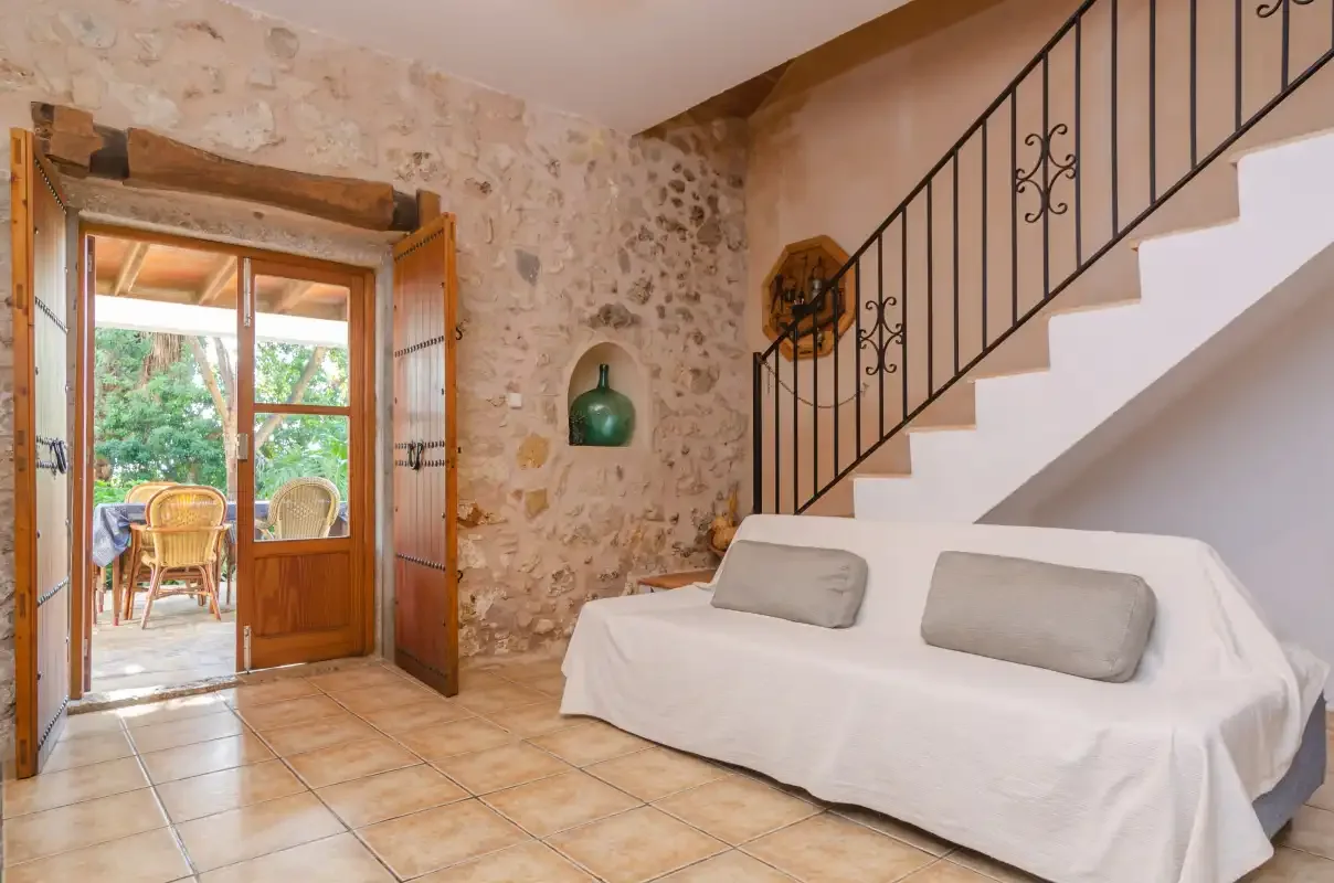 A stone-walled living area with a covered seating area beneath the staircase.