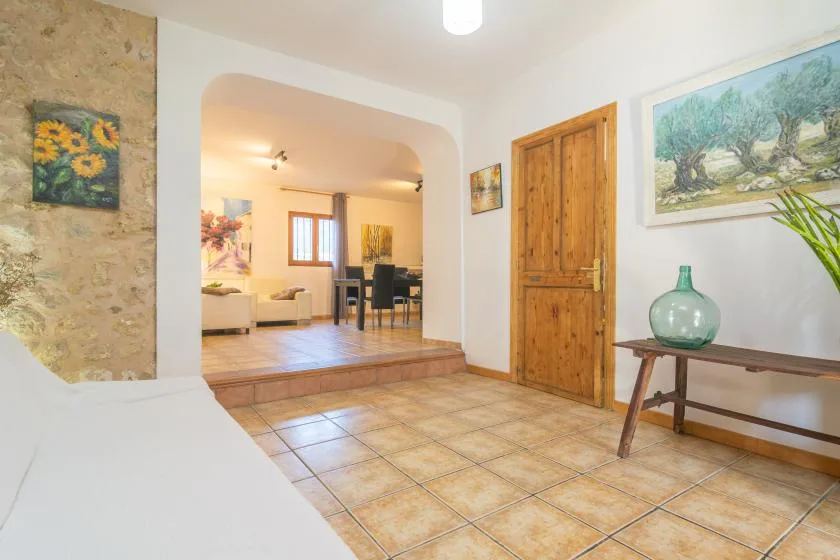 A tiled entryway opens into a living and dining area, with a wooden door.
