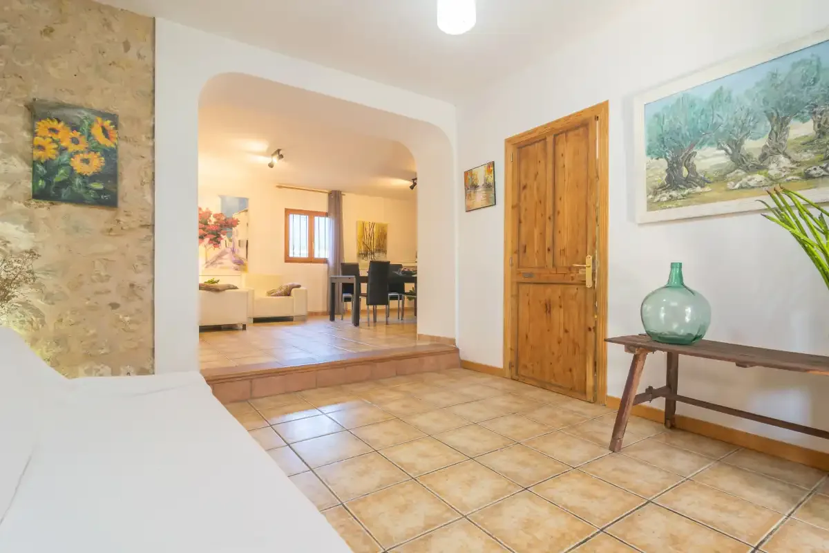 A tiled entryway opens into a living and dining area with a wooden door.