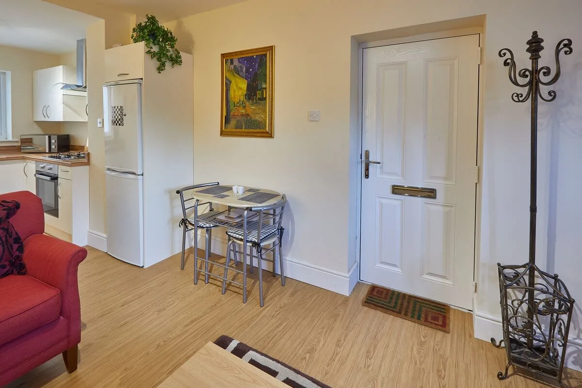 Una pequeña zona de comedor junto a la cocina, con mesa y sillas.