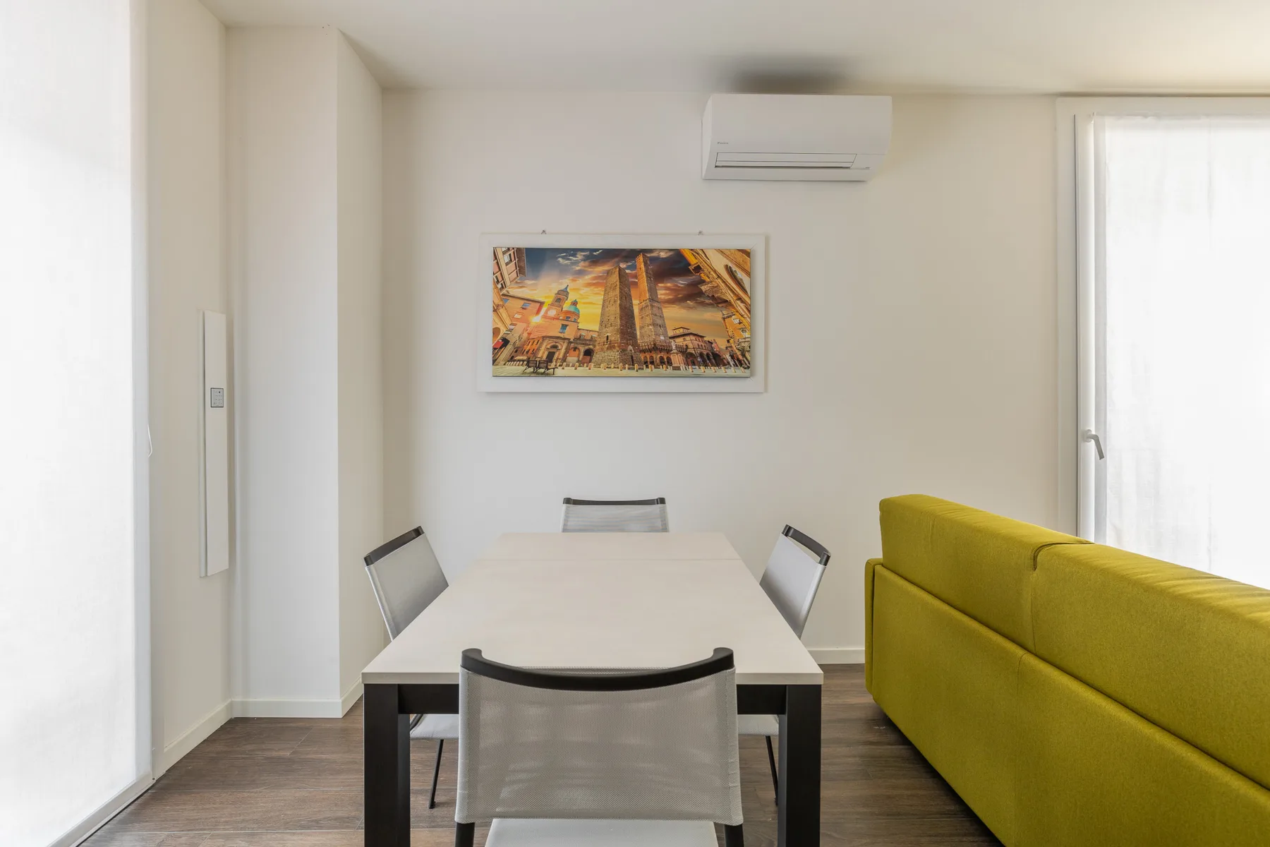 Comedor con mesa y sillas junto a un sofá amarillo brillante.