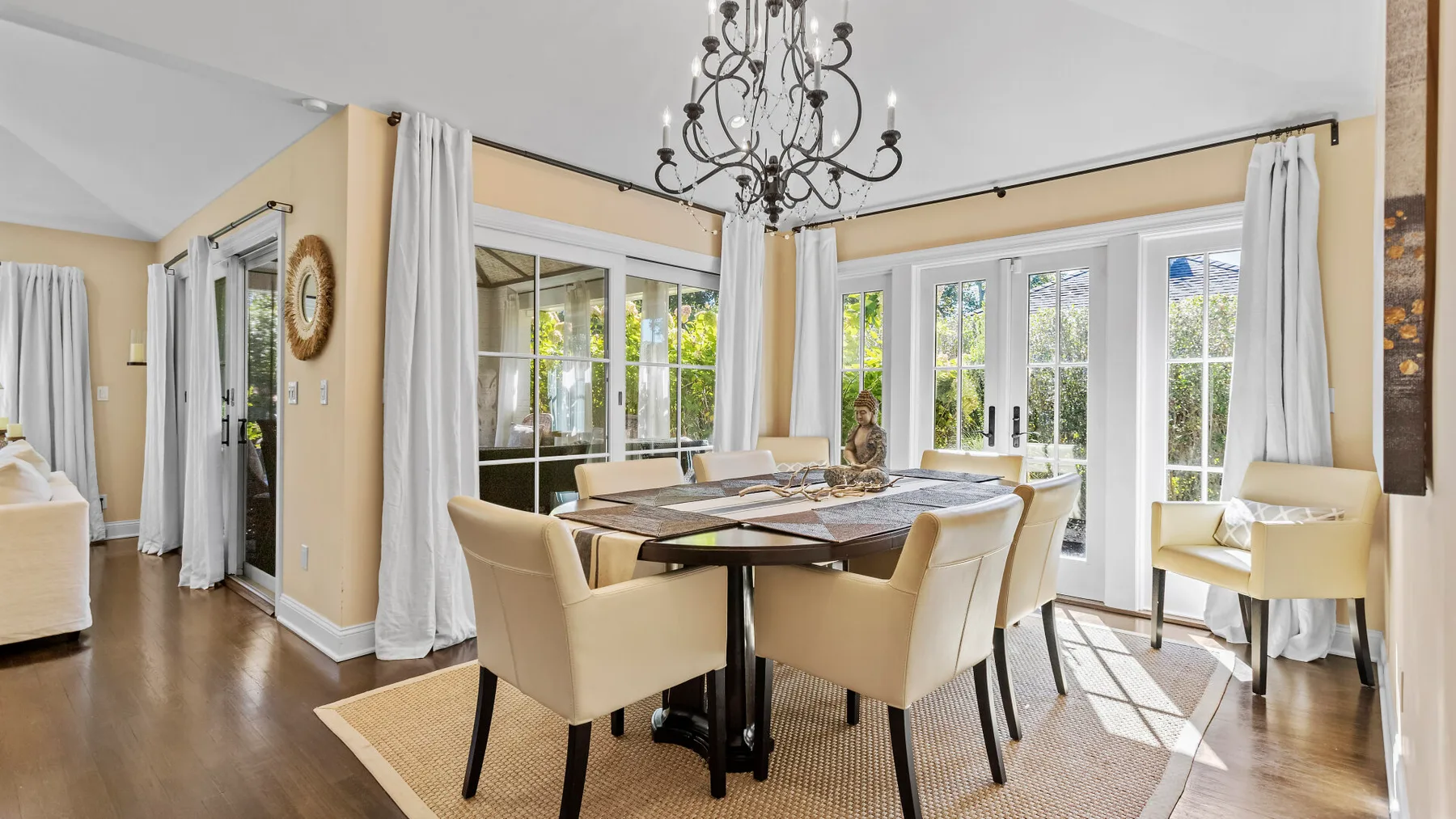 Un comedor luminoso con una mesa, sillas y grandes ventanas.