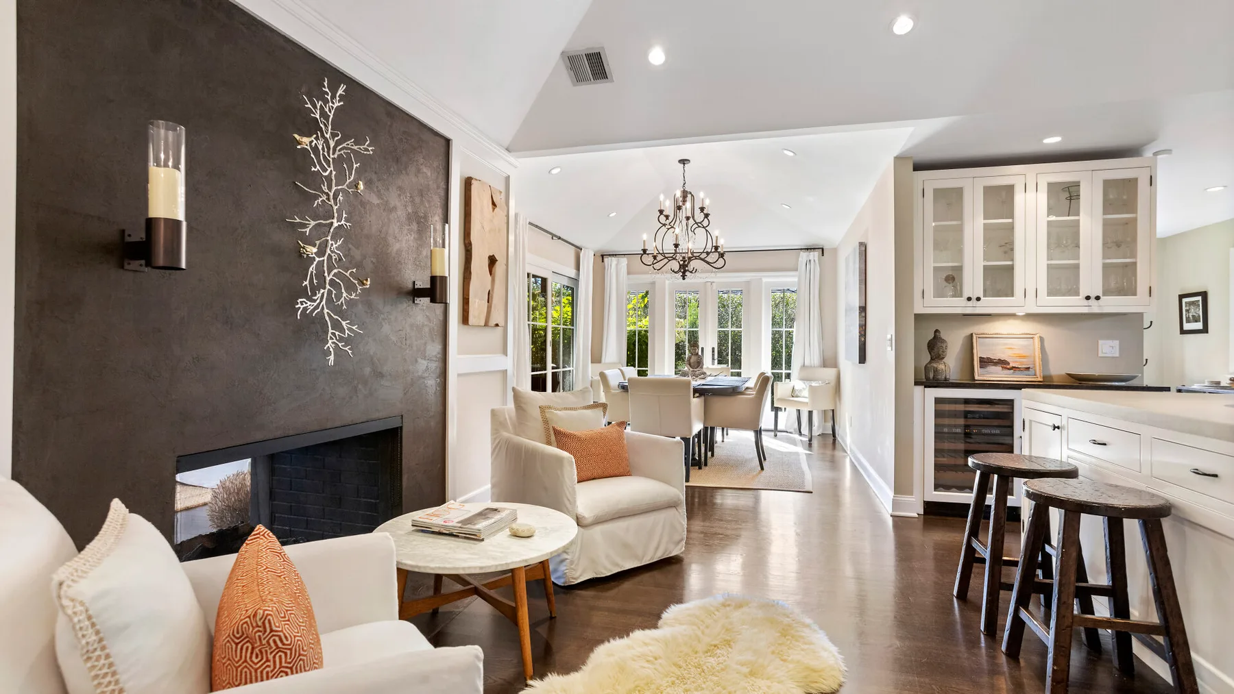 Sala de estar y comedor de concepto abierto con chimenea e isla de cocina.