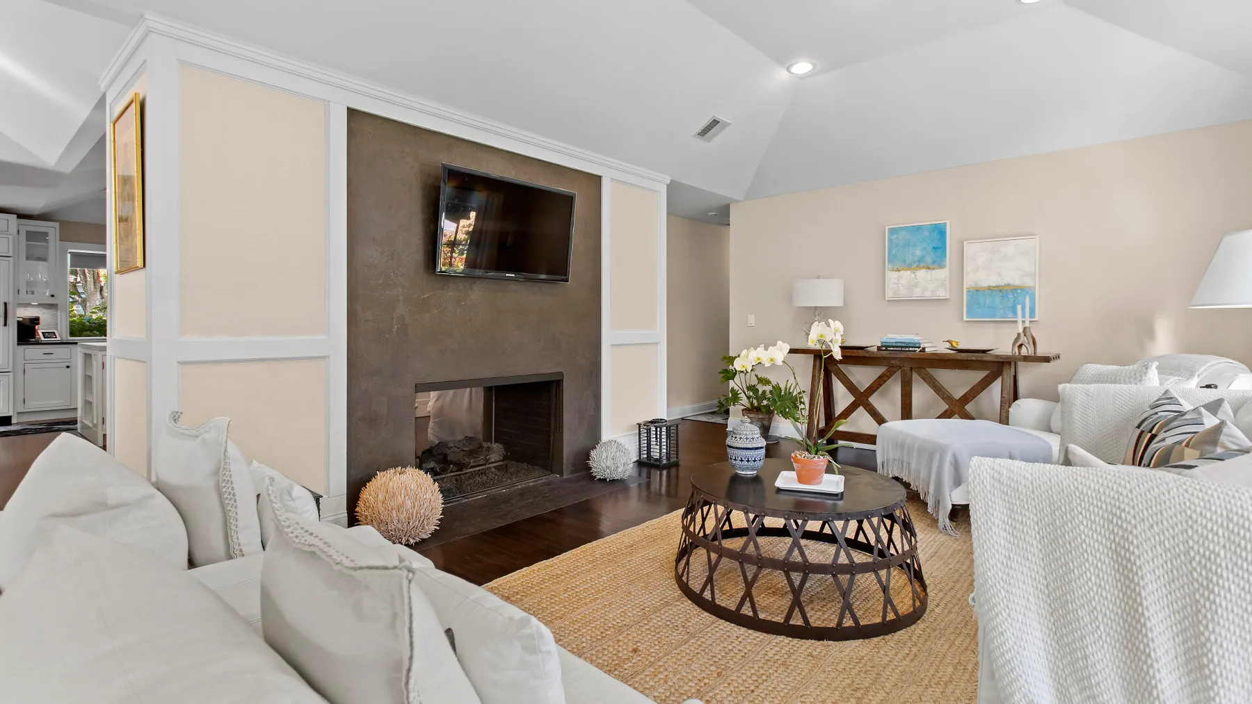 Una sala de estar con chimenea, televisor y asientos alrededor de una mesa de centro.