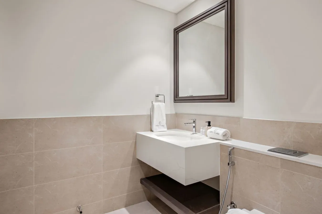 Un lavabo de baño con una pila rectangular está bajo un espejo de pared.
