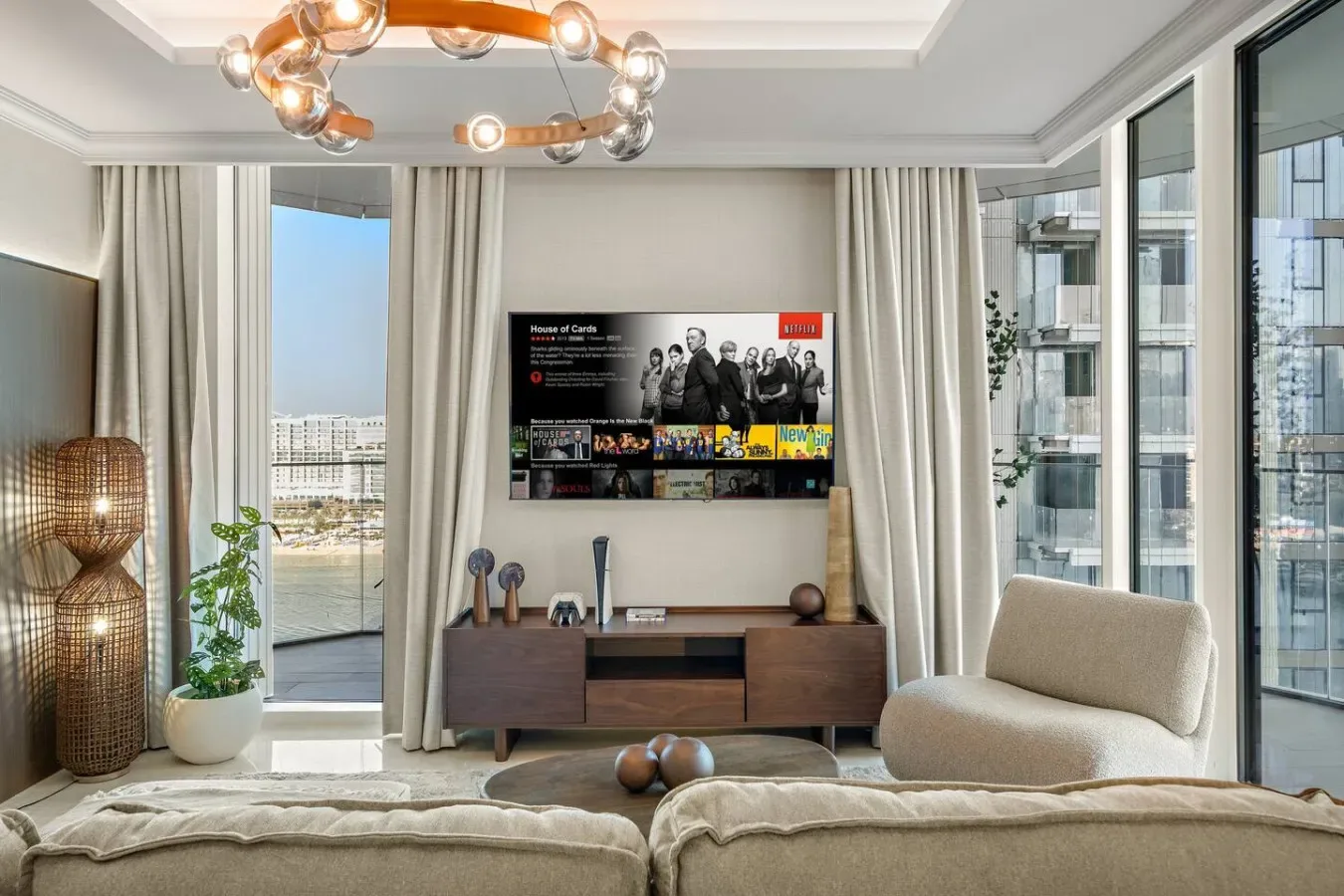 Una sala luminosa con un televisor sobre un mueble de madera y asientos.