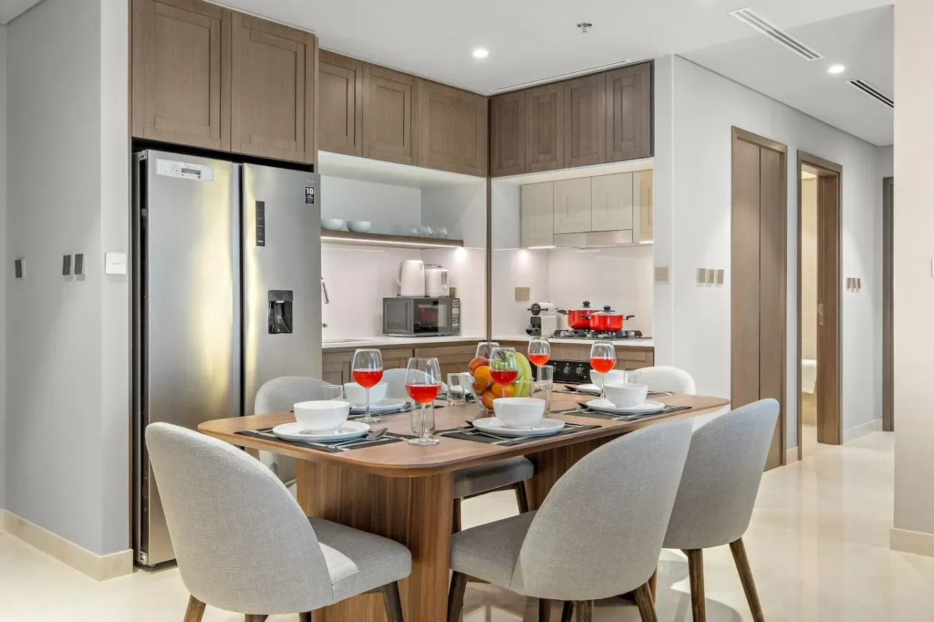 Comedor con una mesa de madera preparada junto a la cocina.