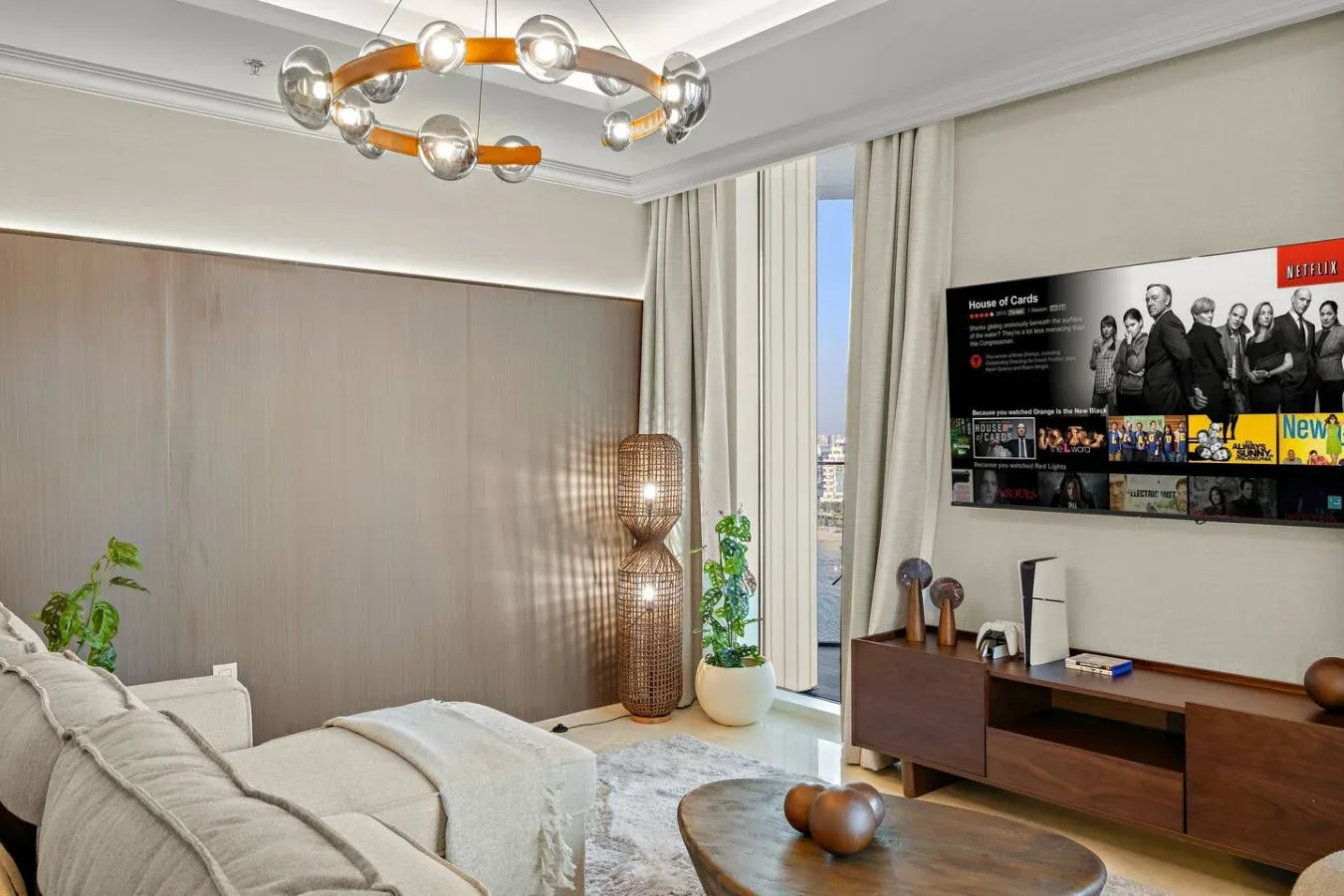 Un dormitorio moderno con una cama, un mueble bajo de madera y un televisor en la pared.