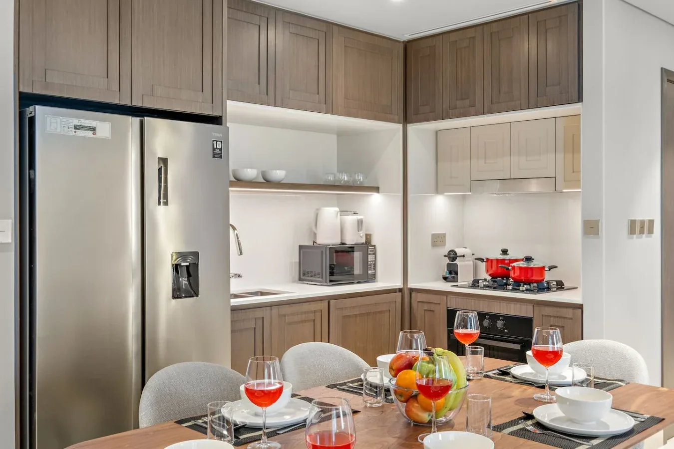 Una cocina moderna con una mesa de comedor preparada con platos y bebidas.