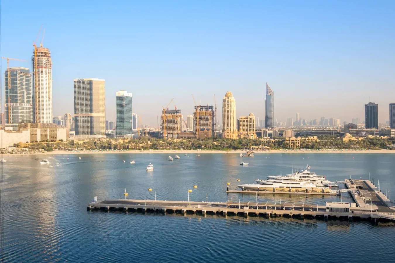 Un horizonte urbano se alza detrás de una marina y un largo muelle.