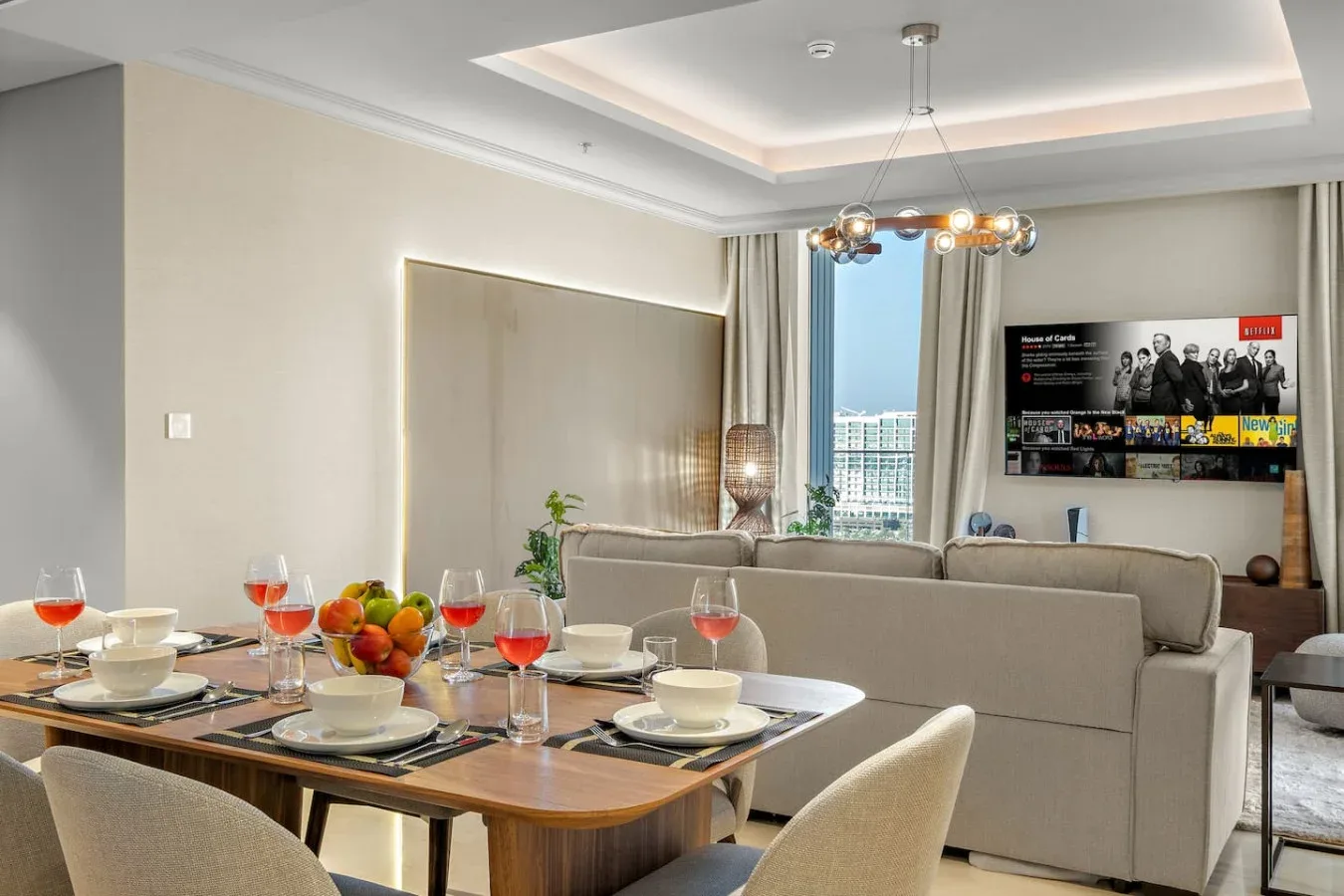 Una sala de estar con una mesa de comedor junto a una zona de asientos y un televisor.