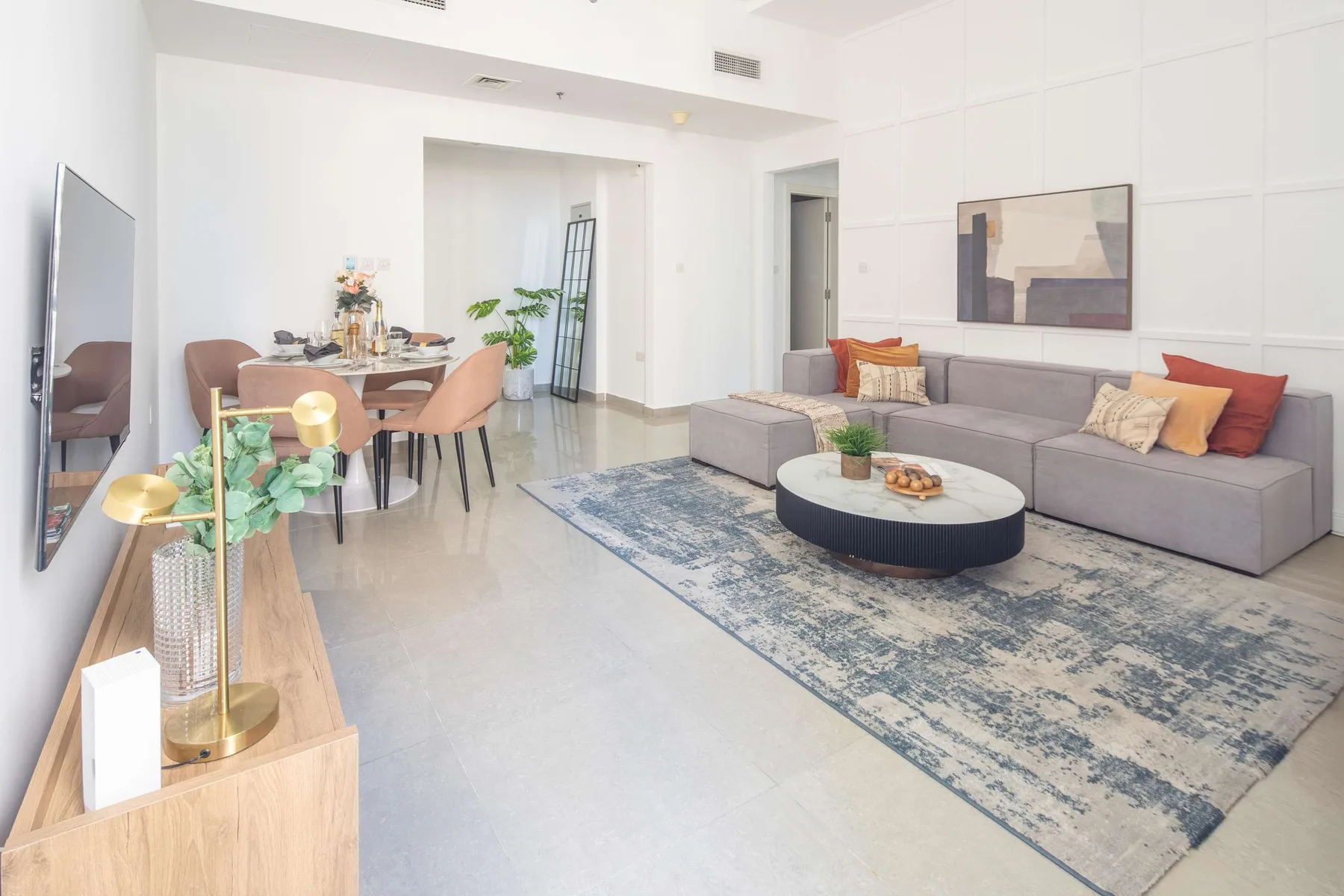 A bright living room with seating around a coffee table and an adjoining dining area.