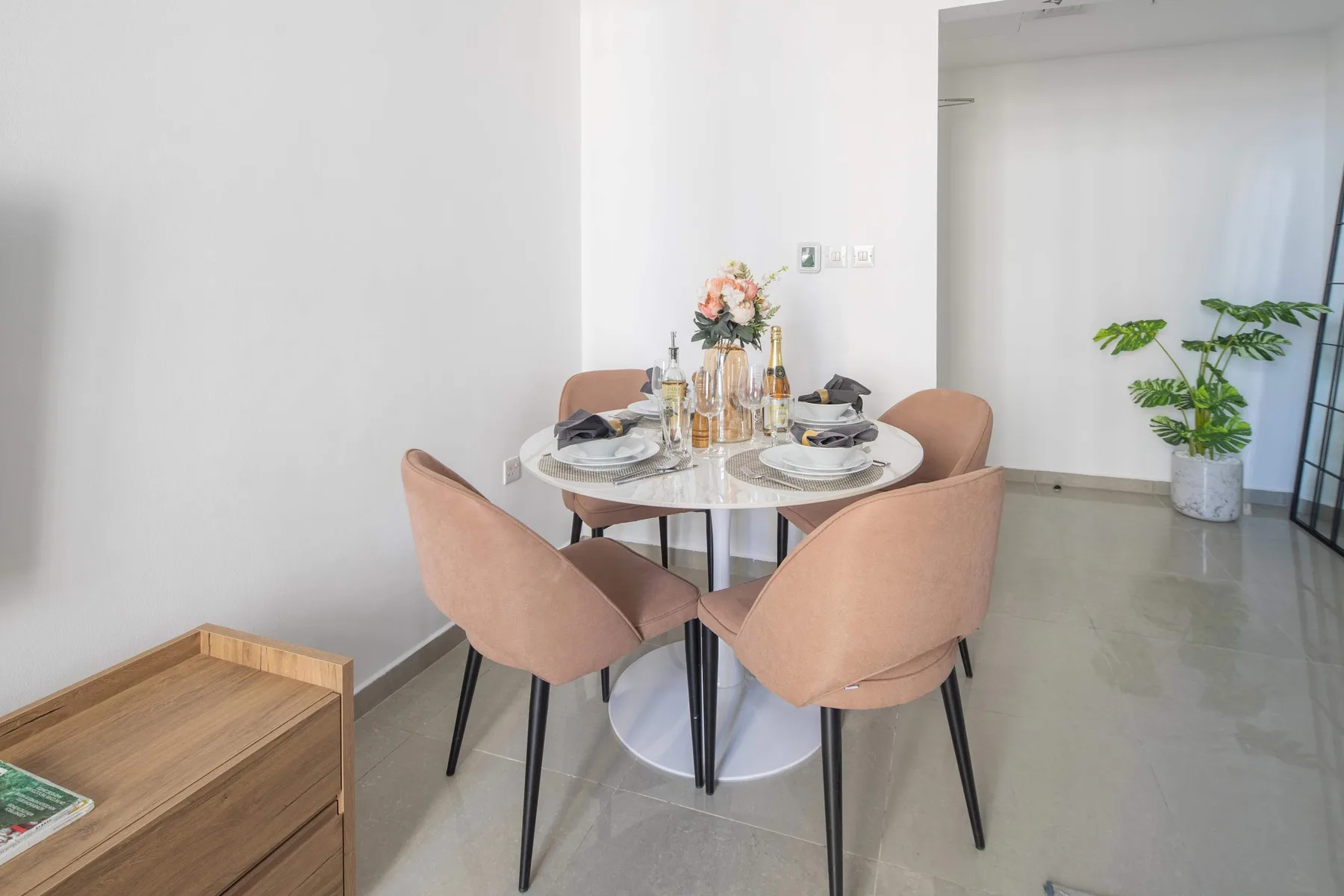 Comedor con una mesa redonda puesta con platos y flores.