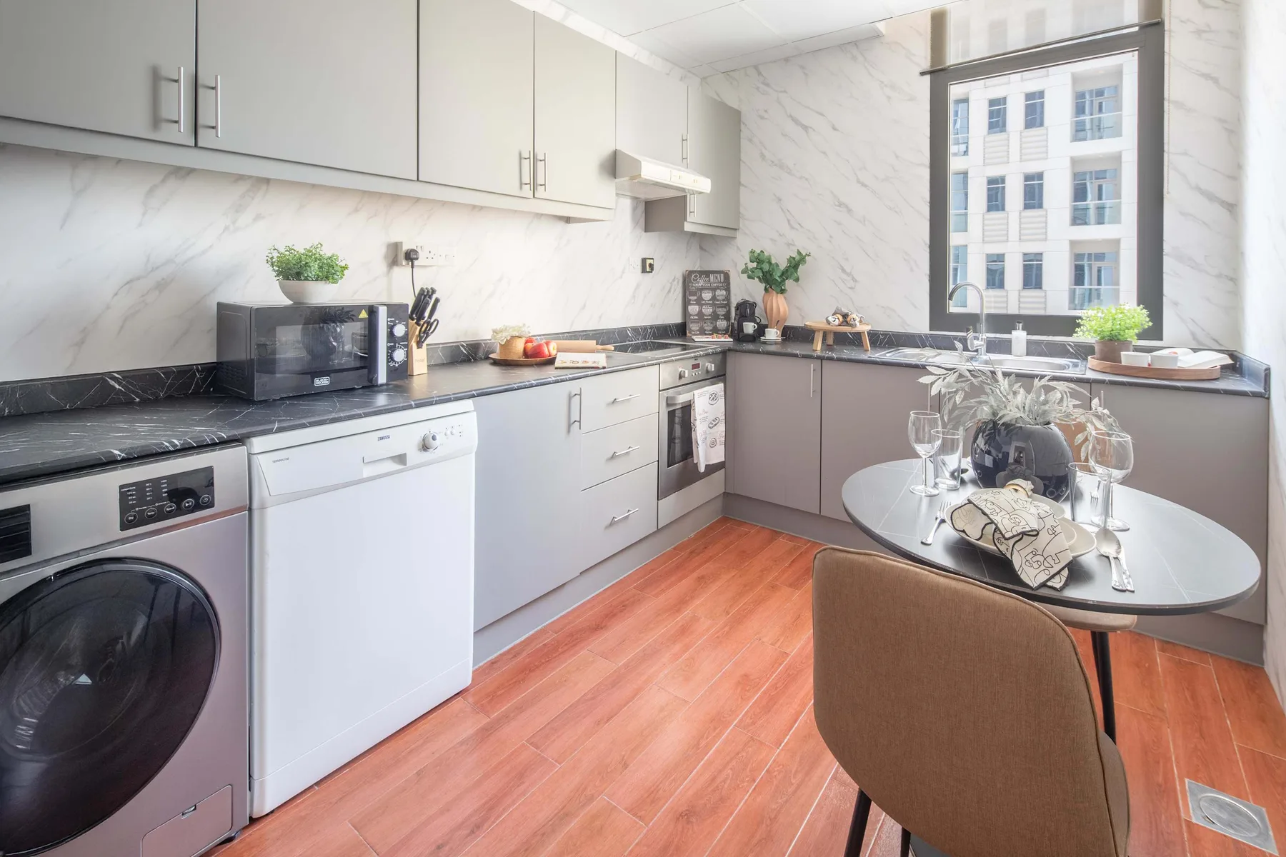 Una cocina luminosa con una mesa de comedor y electrodomésticos de lavandería.