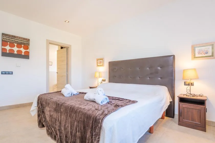 A bright bedroom with a large bed and bedside tables.
