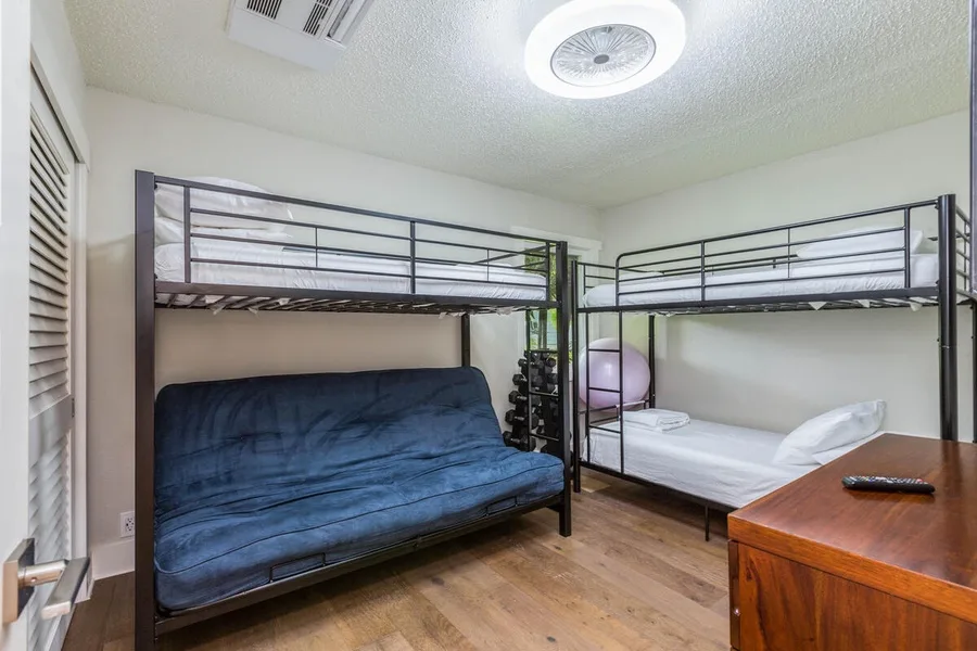 A bedroom with two bunk beds and a blue lower bed.
