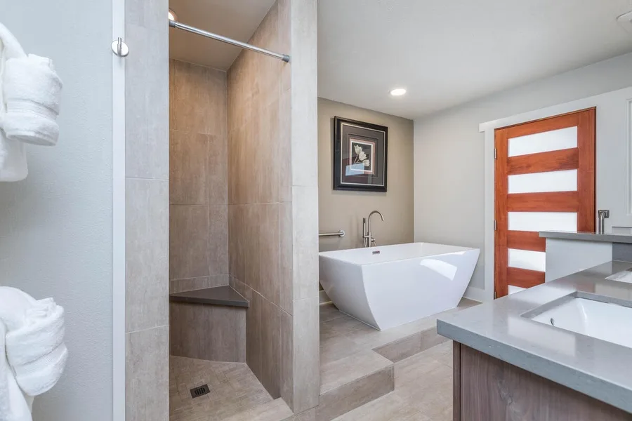 A modern bathroom features a walk-in shower, a freestanding tub, and a vanity.