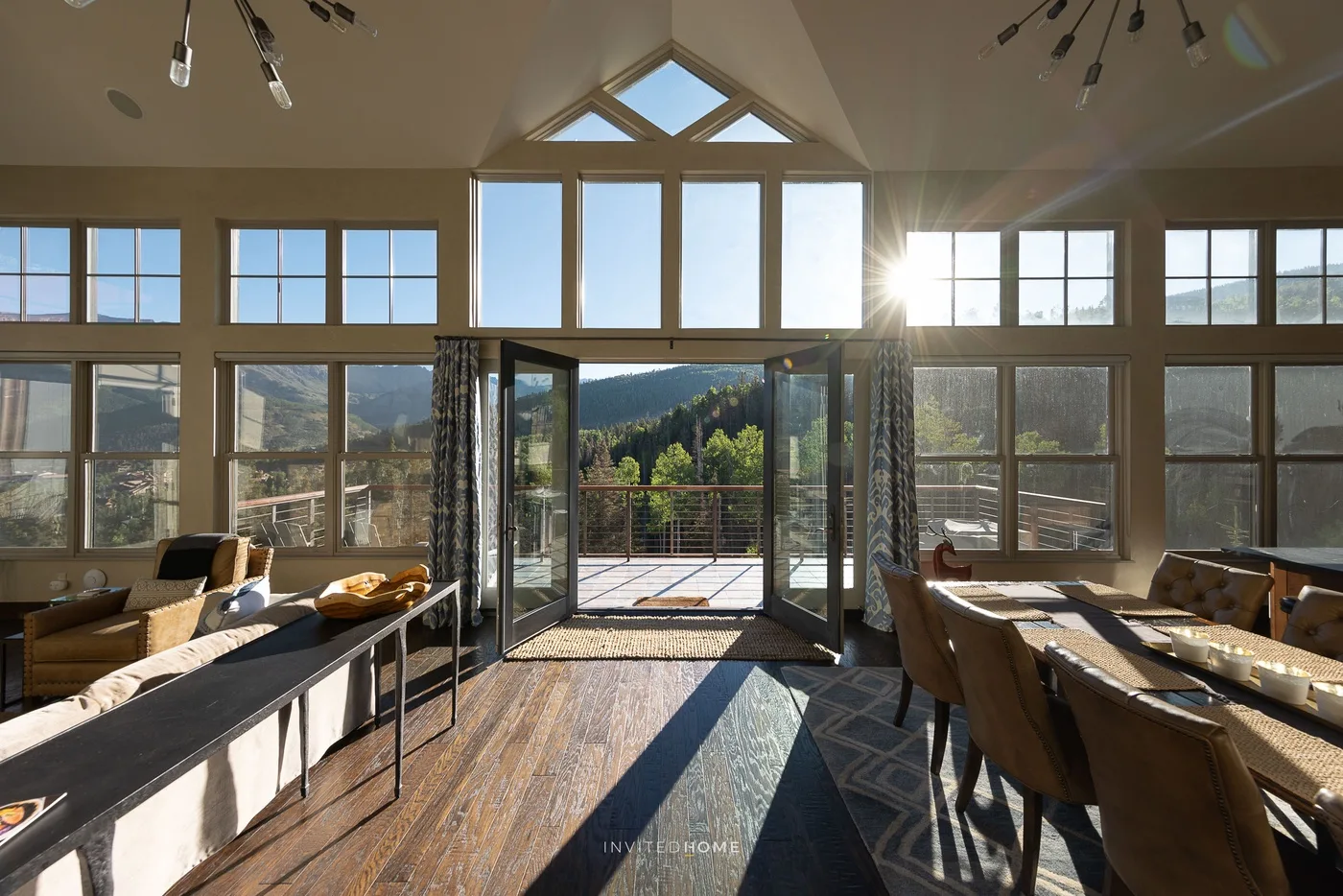 A bright dining room opens onto a deck through large glass doors.