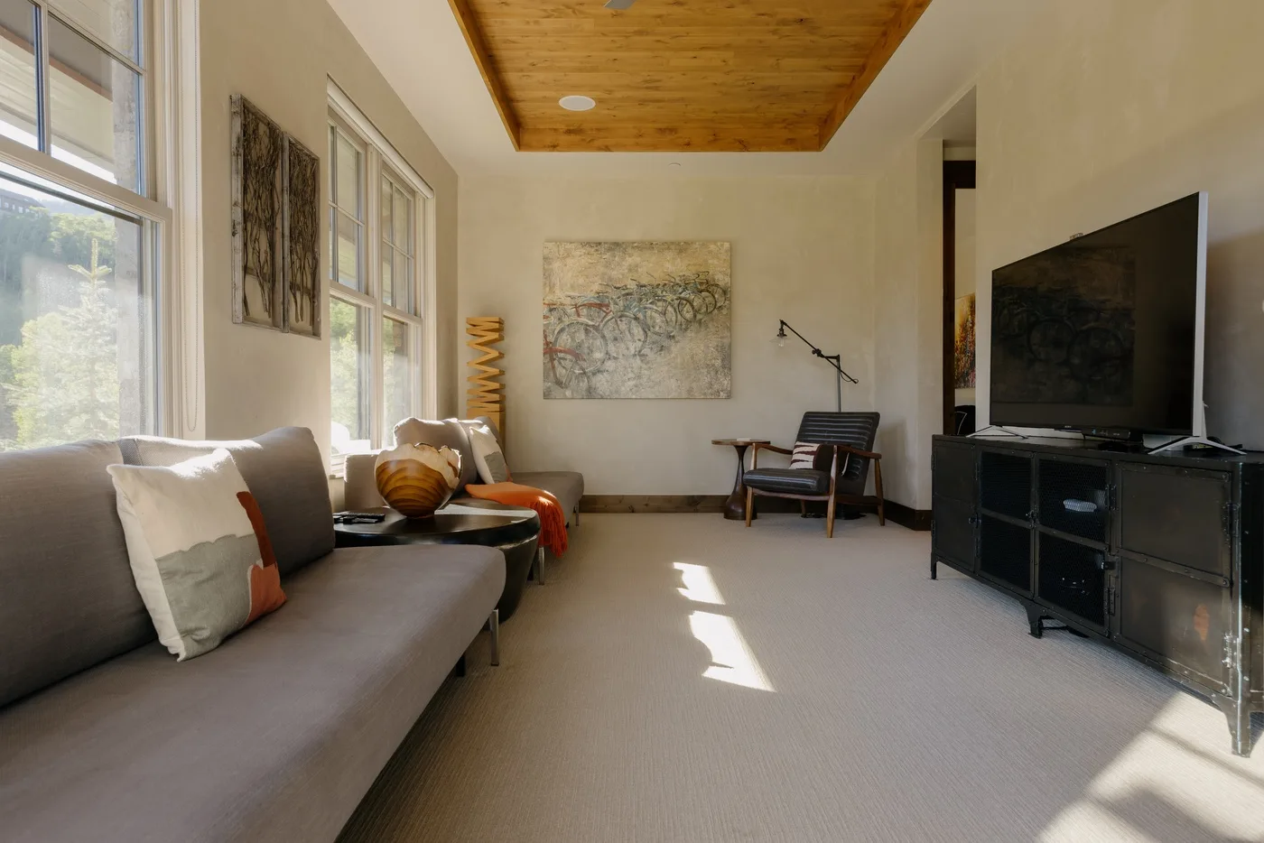 A living room with seating, wall art, and a television.