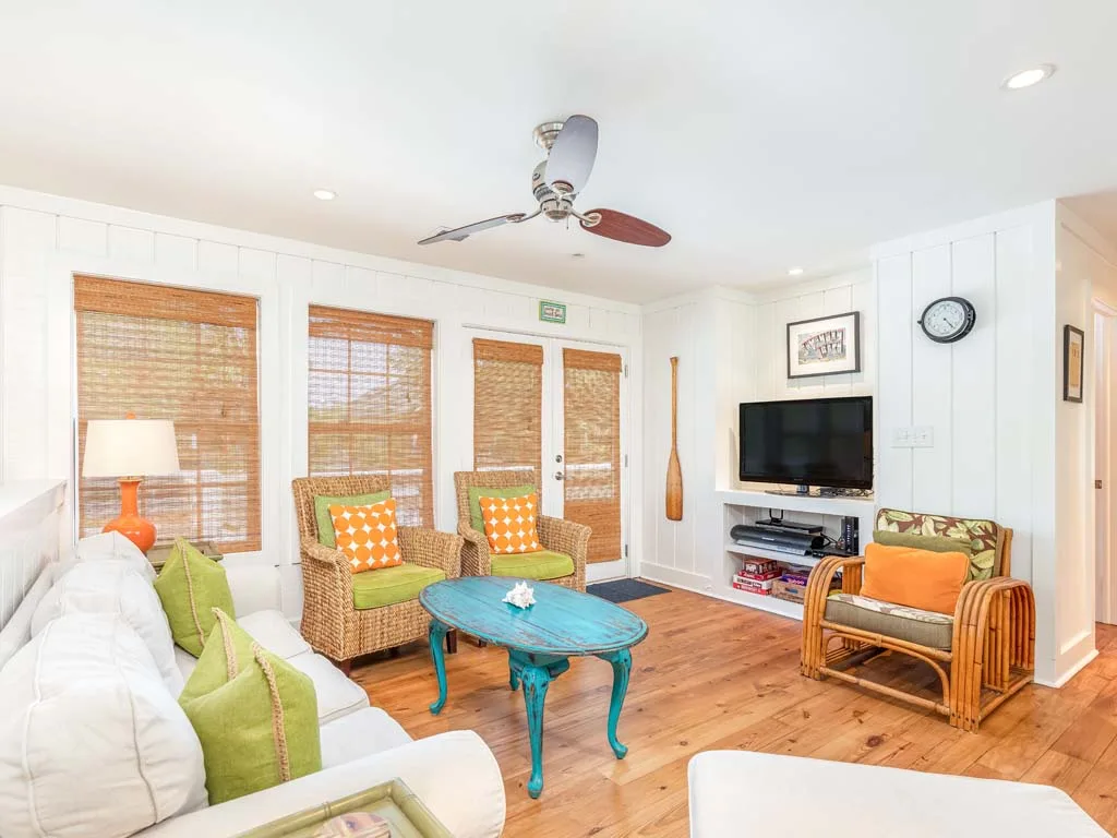 A bright living room with wicker seating and a turquoise coffee table.