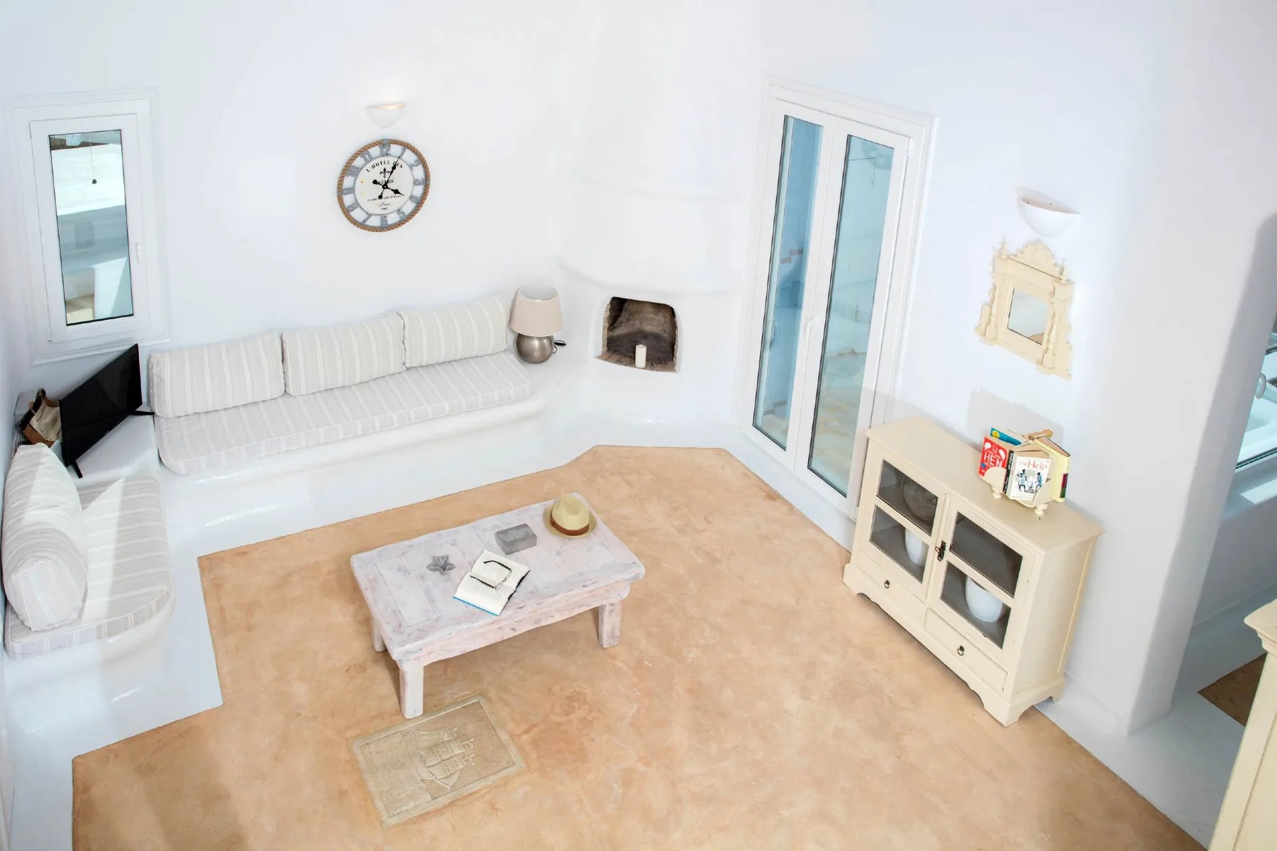 A bright living room with white seating and a coffee table.