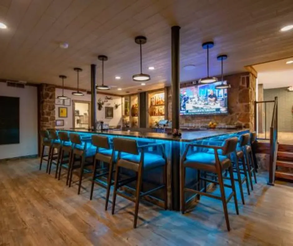 Bar salón con taburetes y un televisor