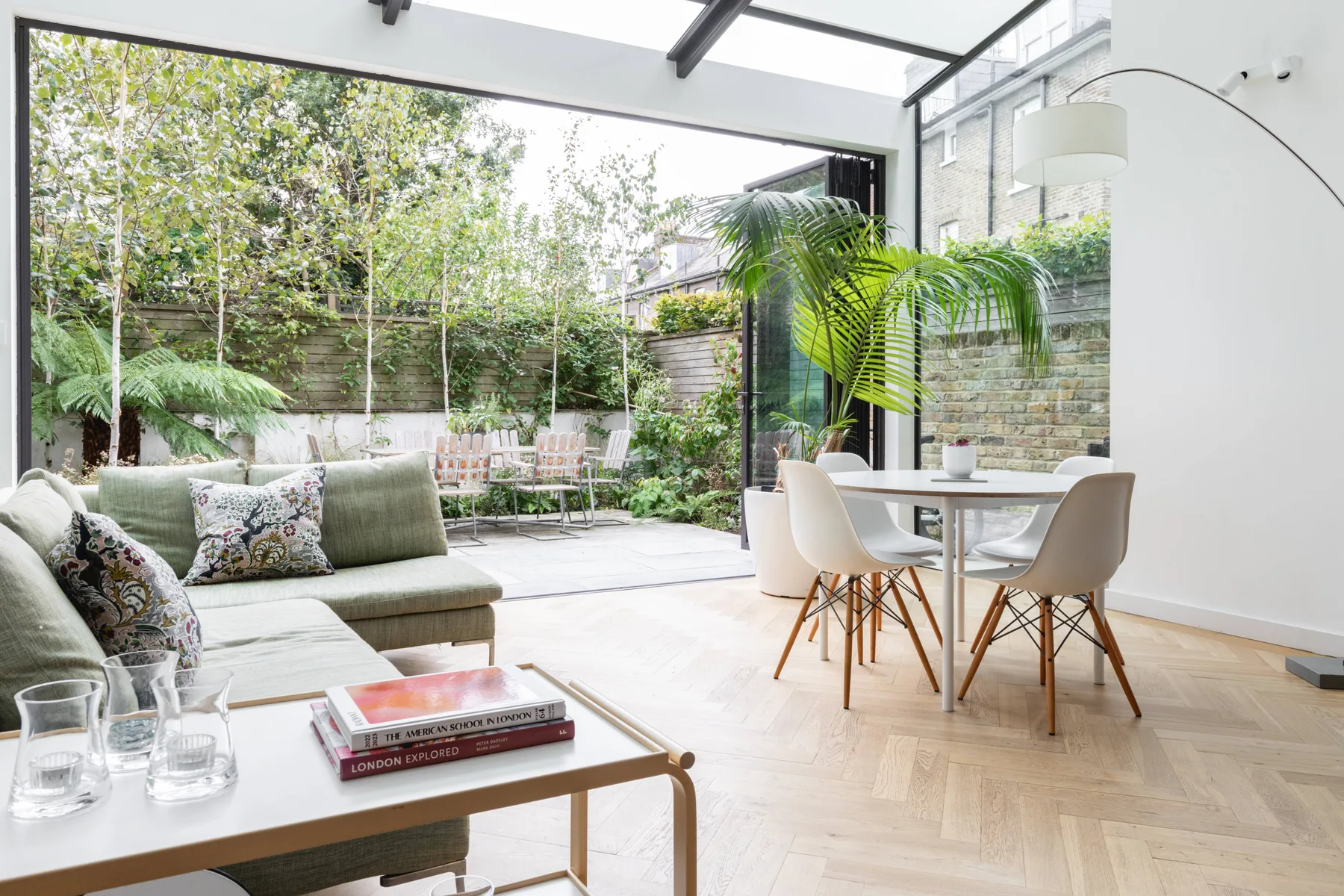 A bright living and dining area opens onto a leafy garden.