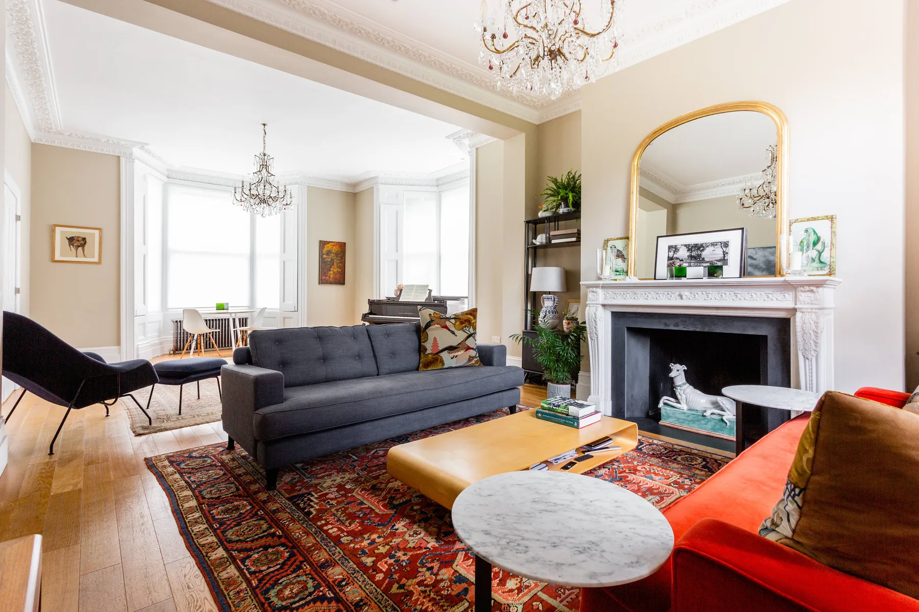 A bright living room with seating around a fireplace and coffee tables.